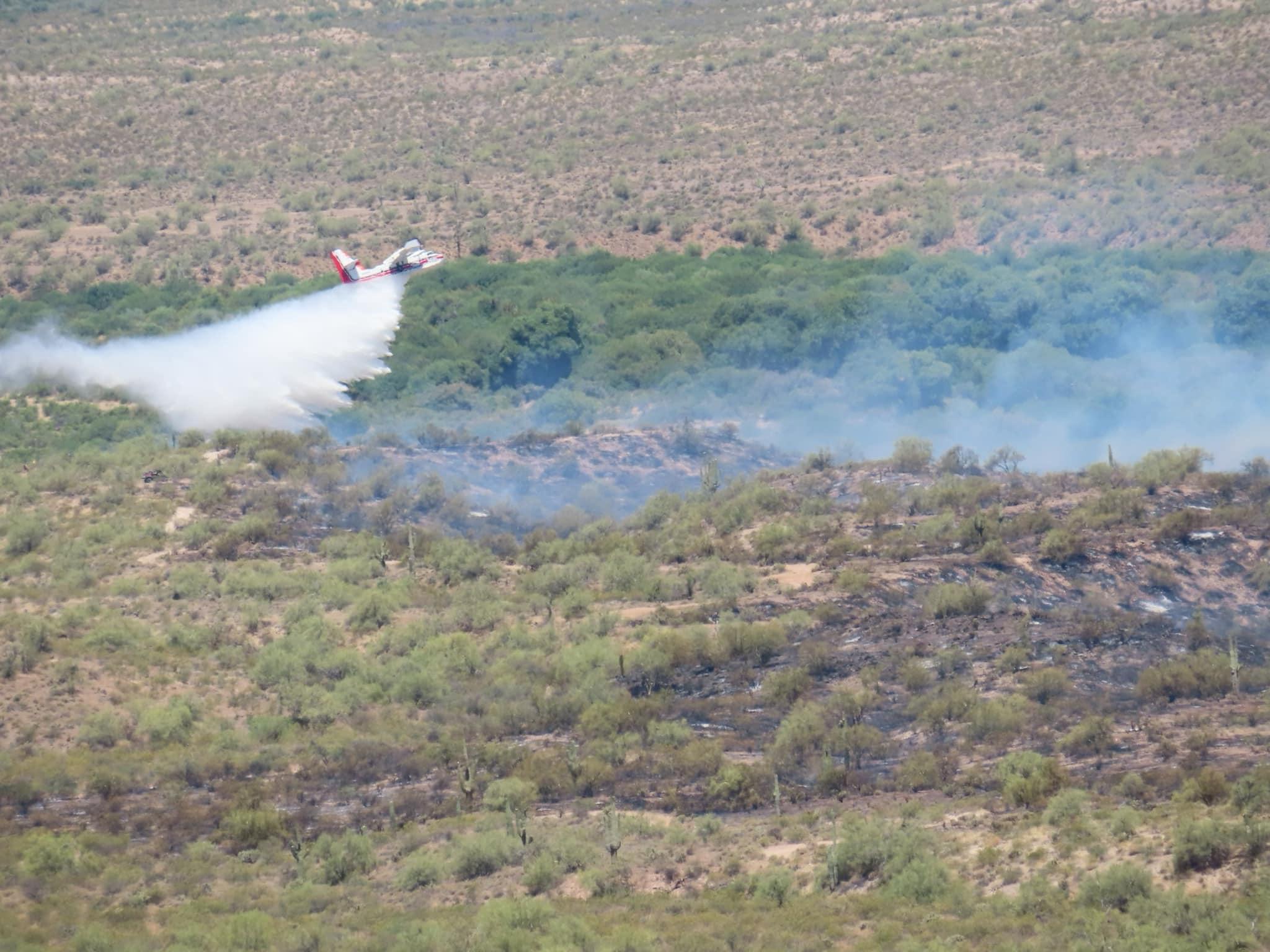 Aircraft dropping water on fire area