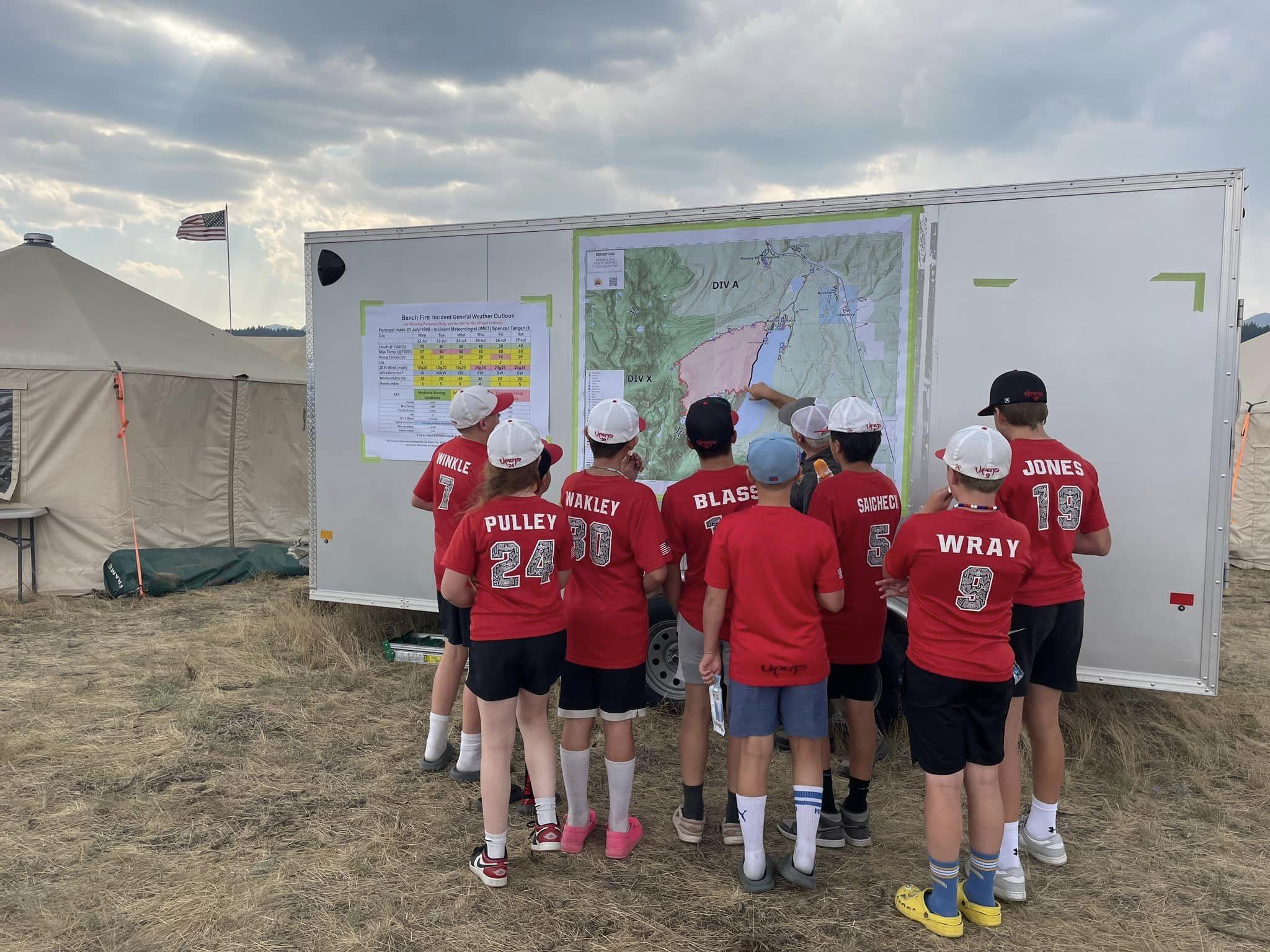 youth baseball players looking at map