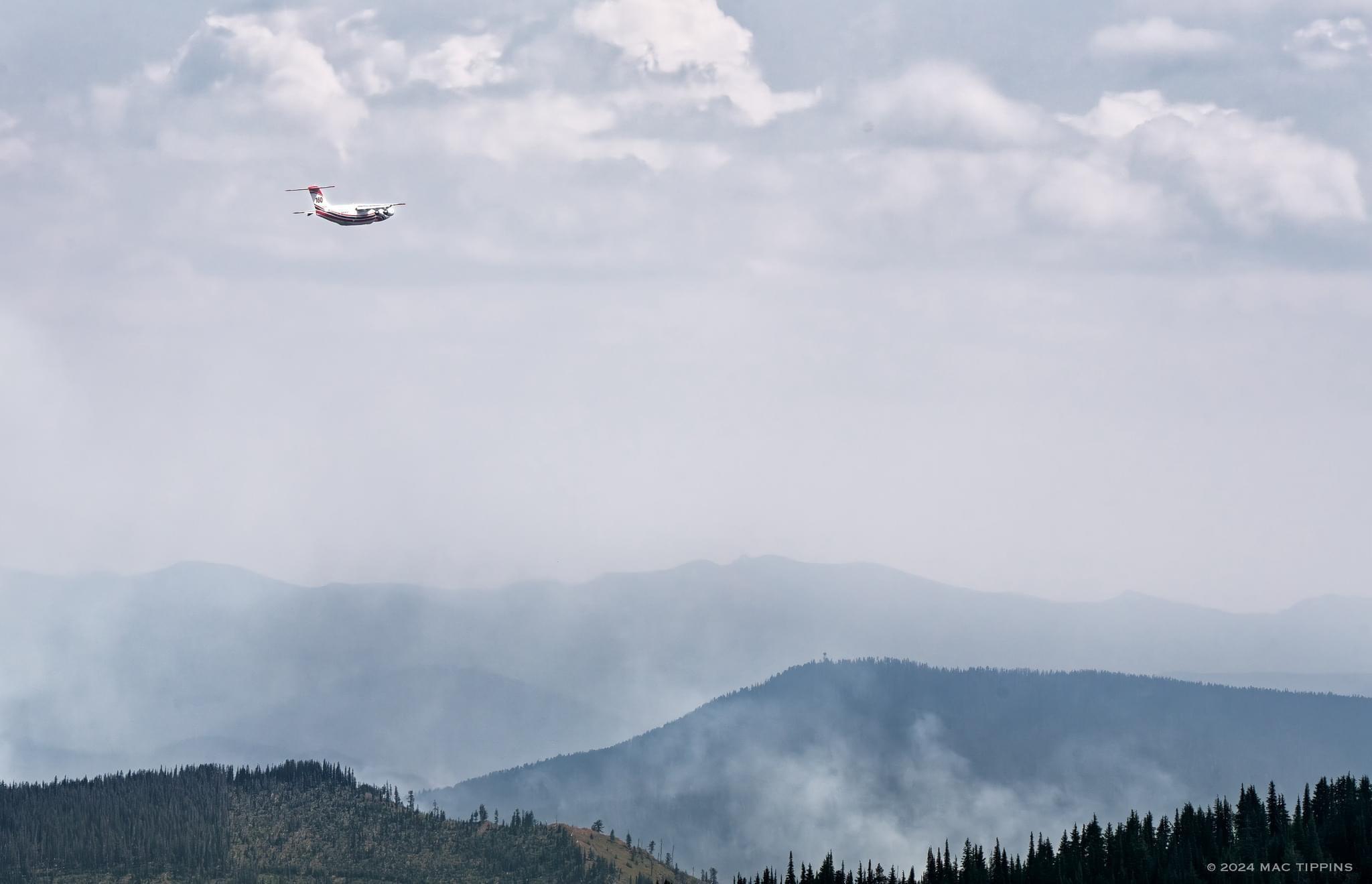 A large air tanker flies over a smoking portion of the Bluff Creek Complex near Avery, ID.