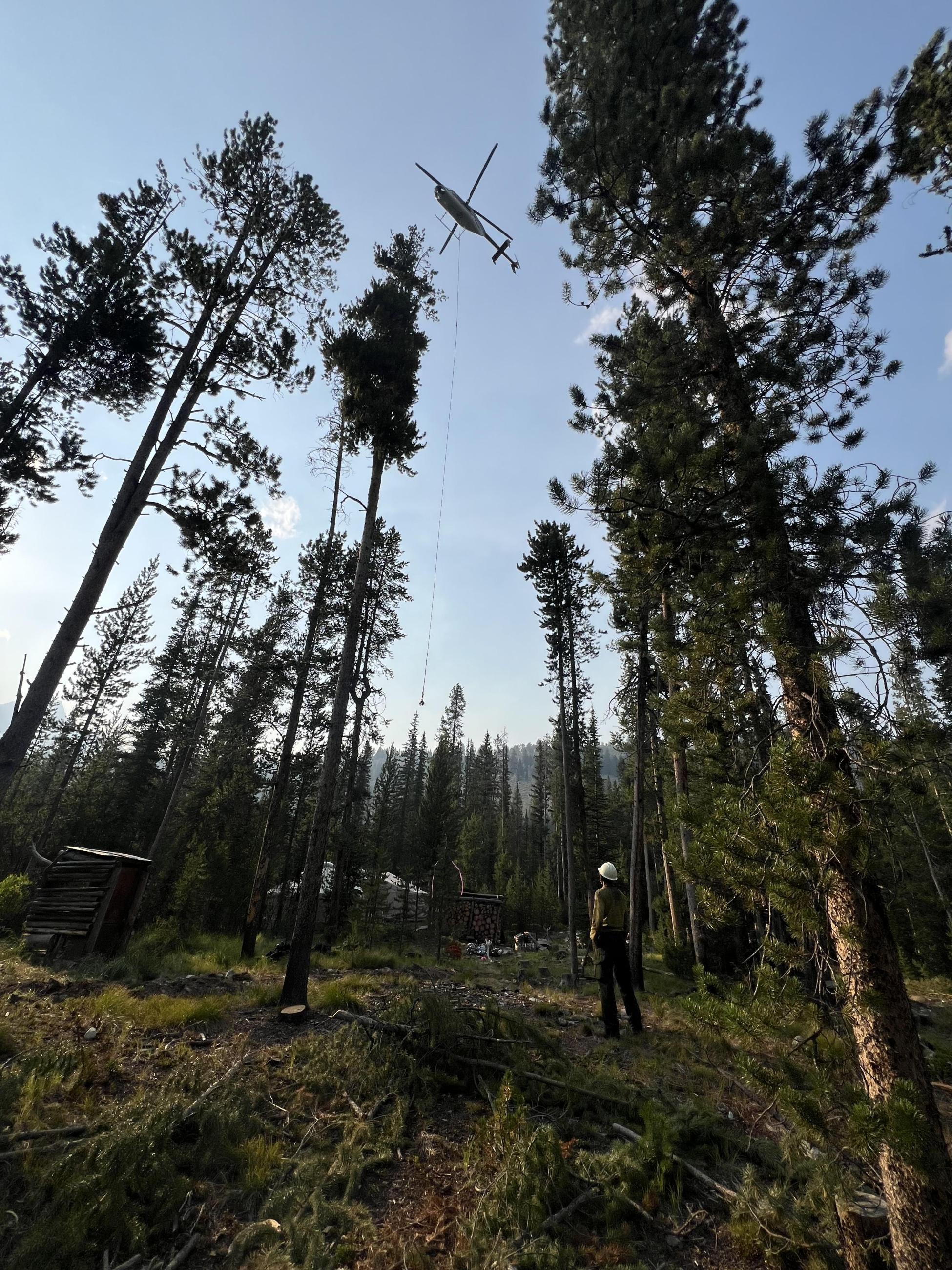 A helicopter flies above the north edge of the fire, July 26, 2024