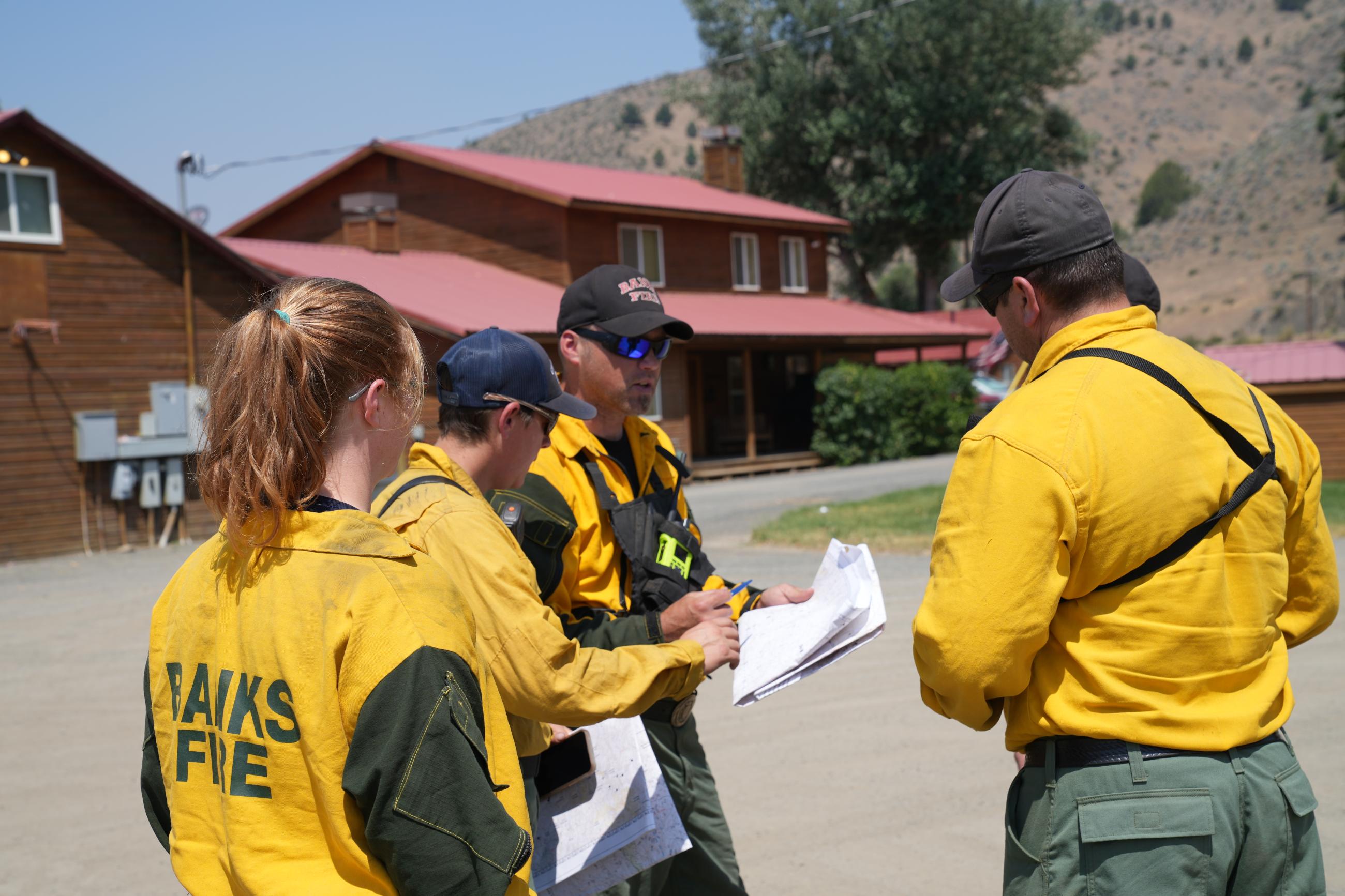 Structural fire personnel huddle around a map