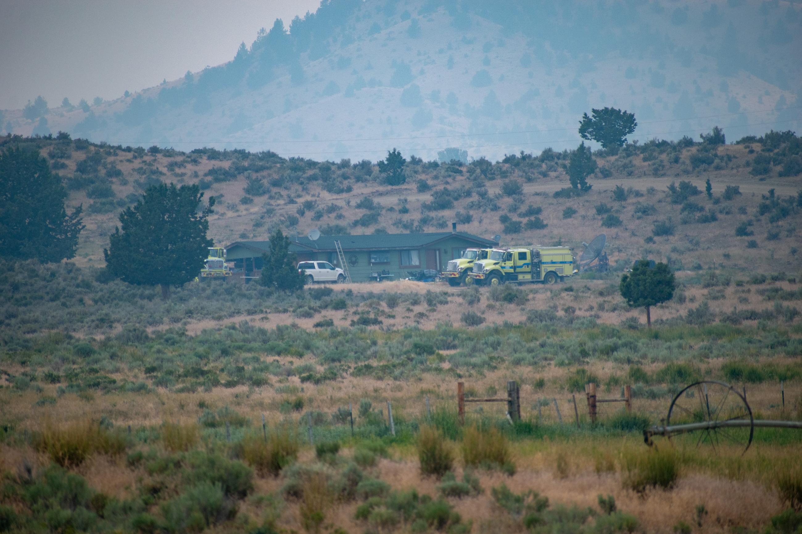 houses in the distance. Hills with shrubs and some trees. 