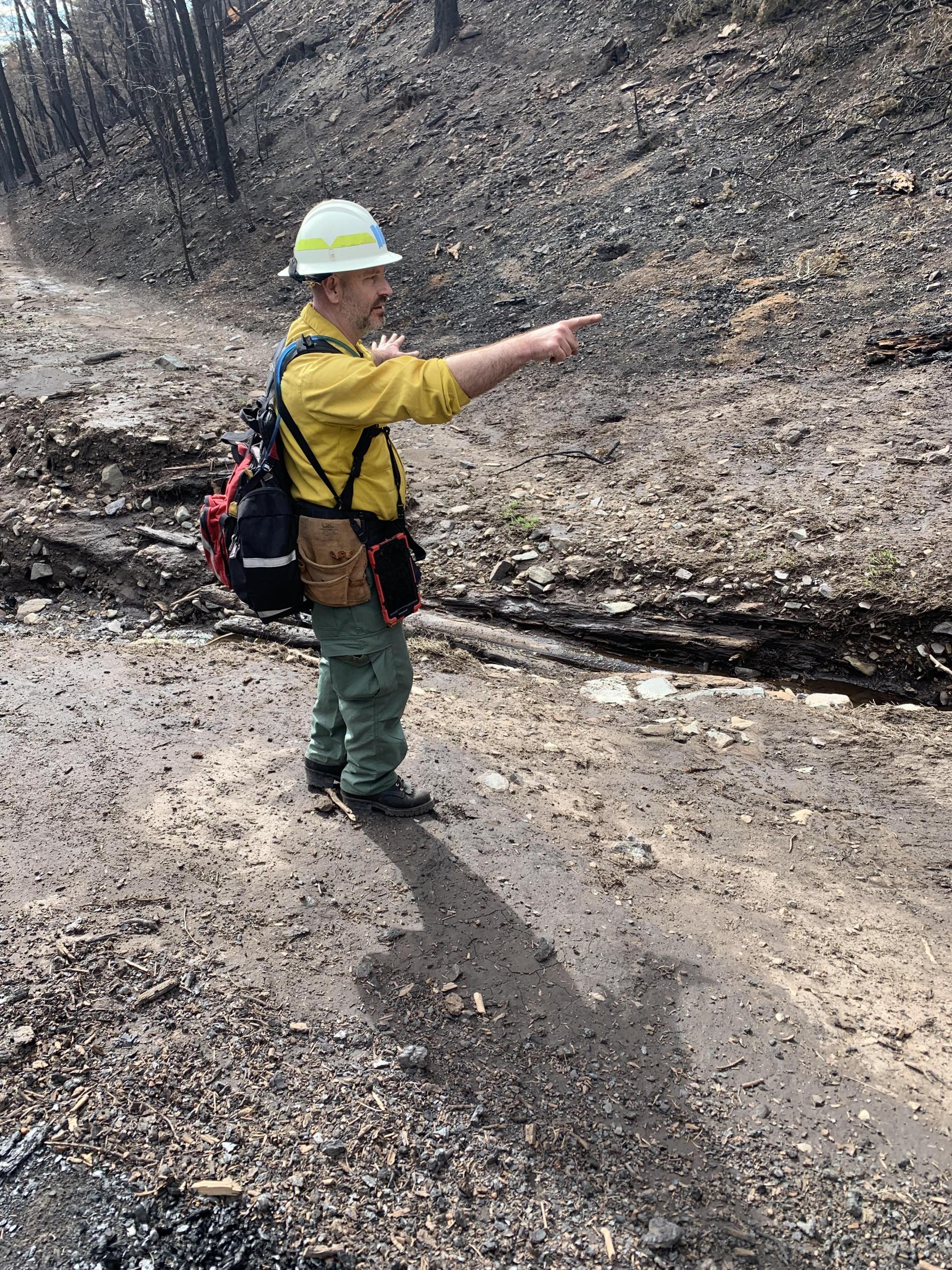 Image showing BAER Hydrologists Evaluate and Discuss Downcut in Channel