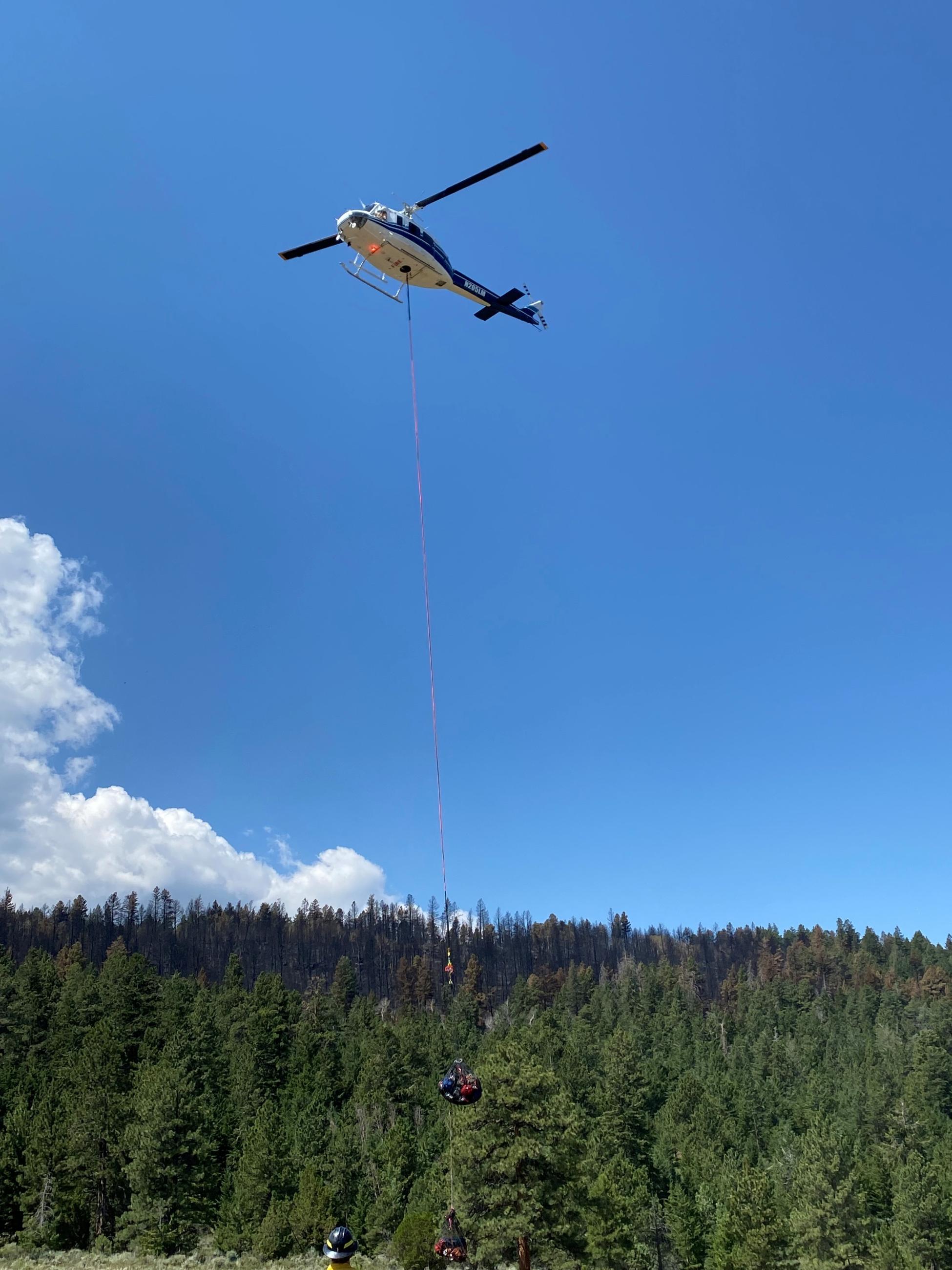 A helicopter is slinging in fire gear for crews on the Speirs Fire.