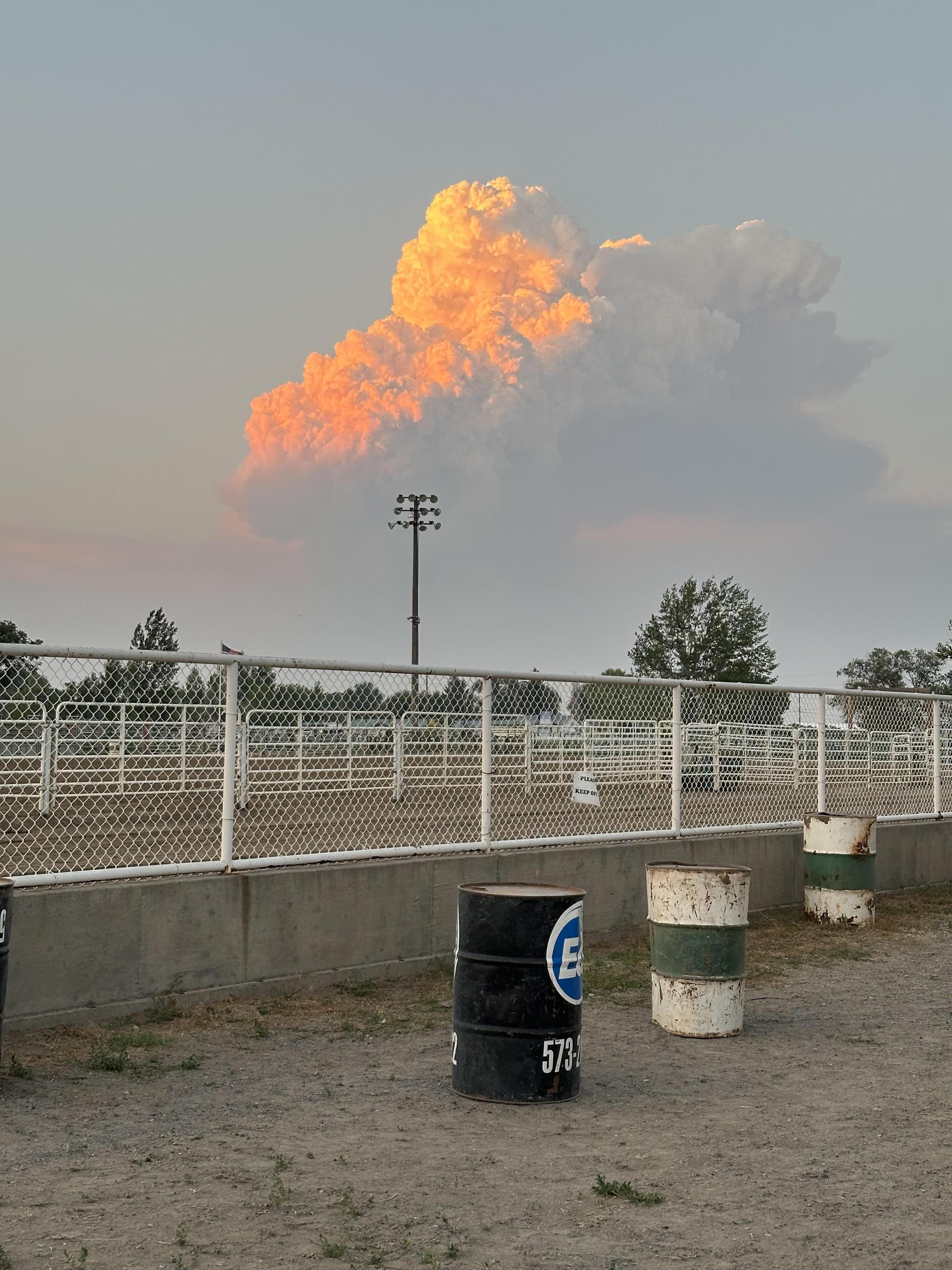 Fire column at distance, fence and barrels