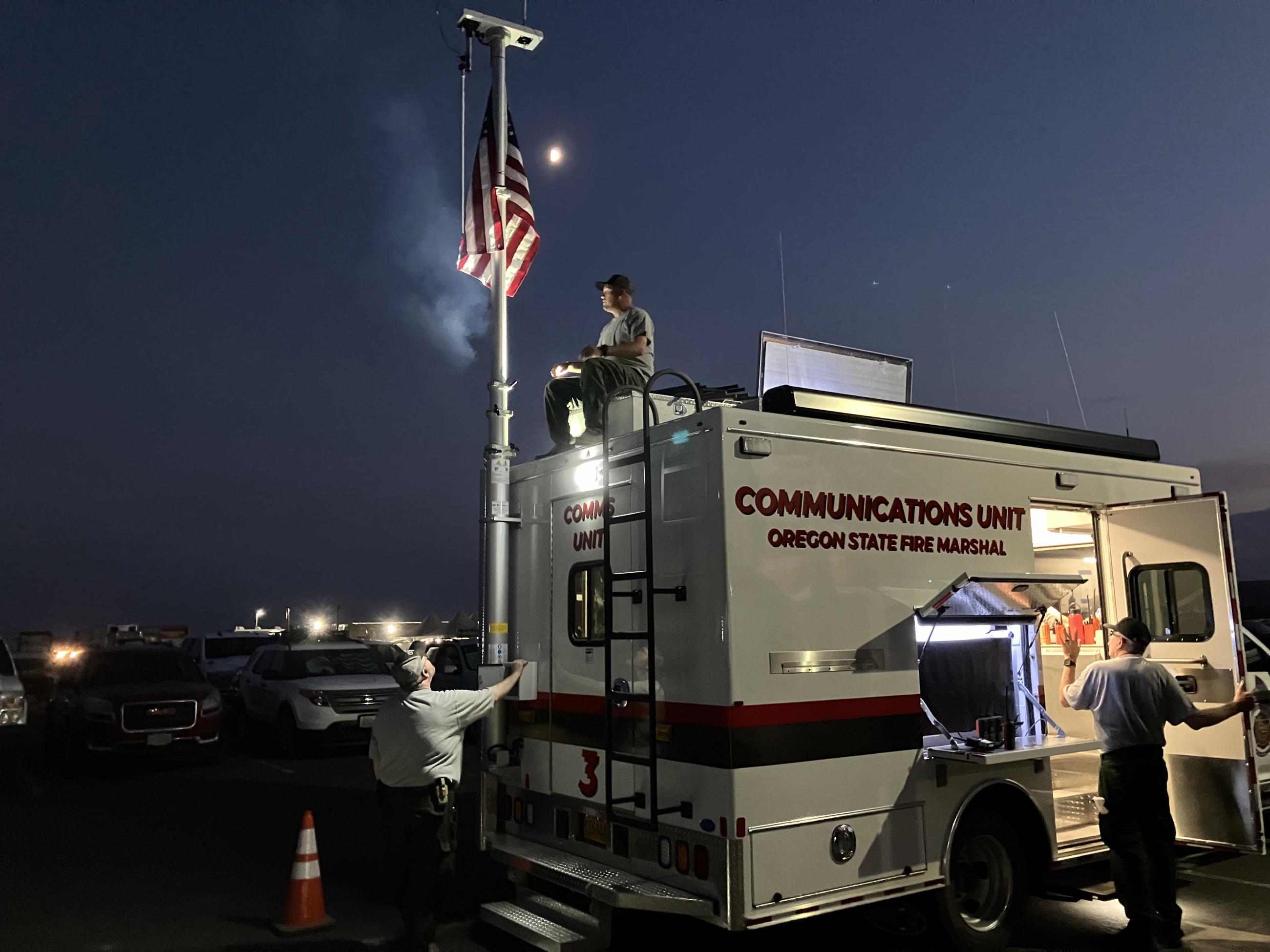 Man next to American Flag atop Oregon State Fire Marshal Communications Truck 