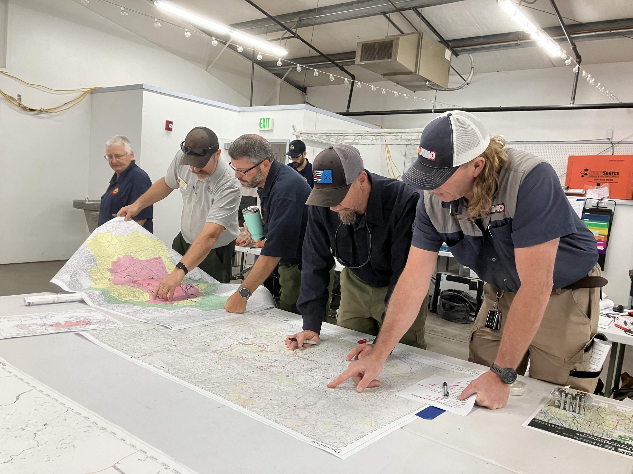 Operations Specialists stand over Map at ICP