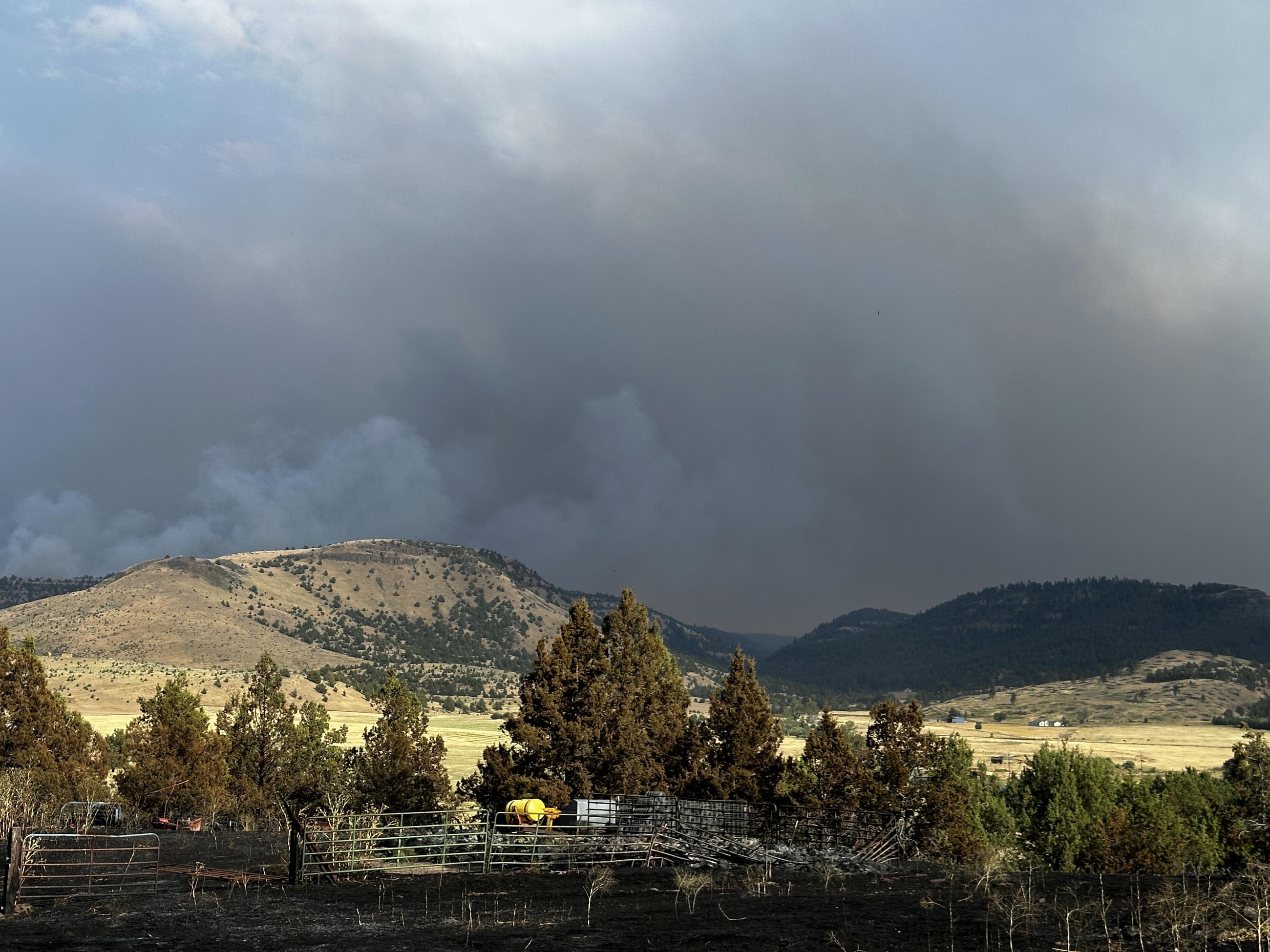 A large dark smoke column is in the background.