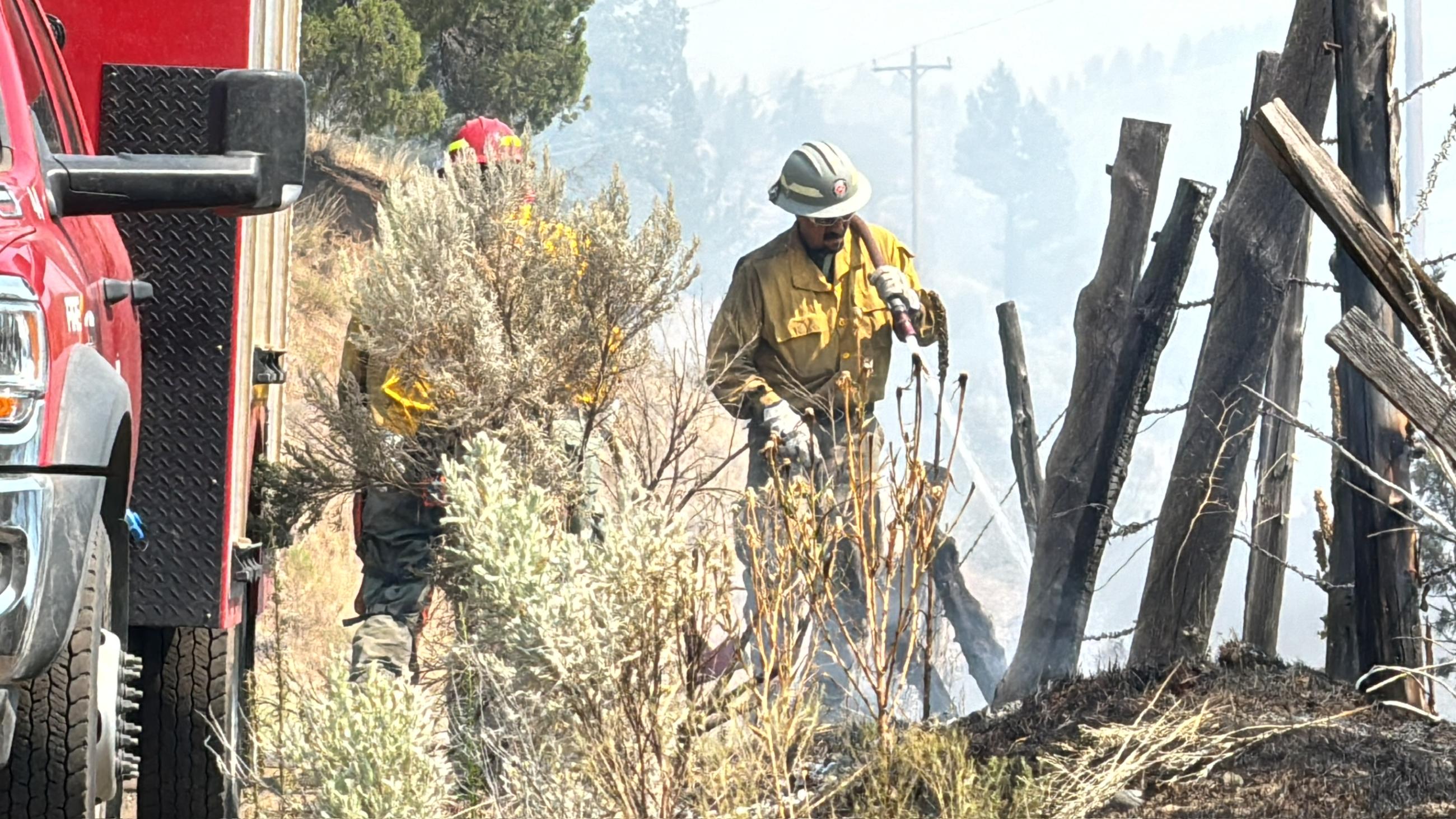 An engine crew mops up along the road and fenceline on the Lone Rock Fire