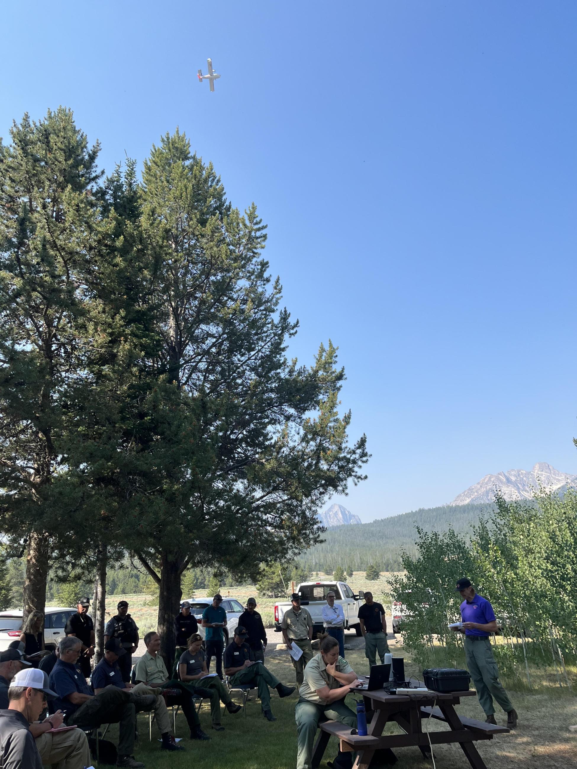 people gathered around talking with airplane in background