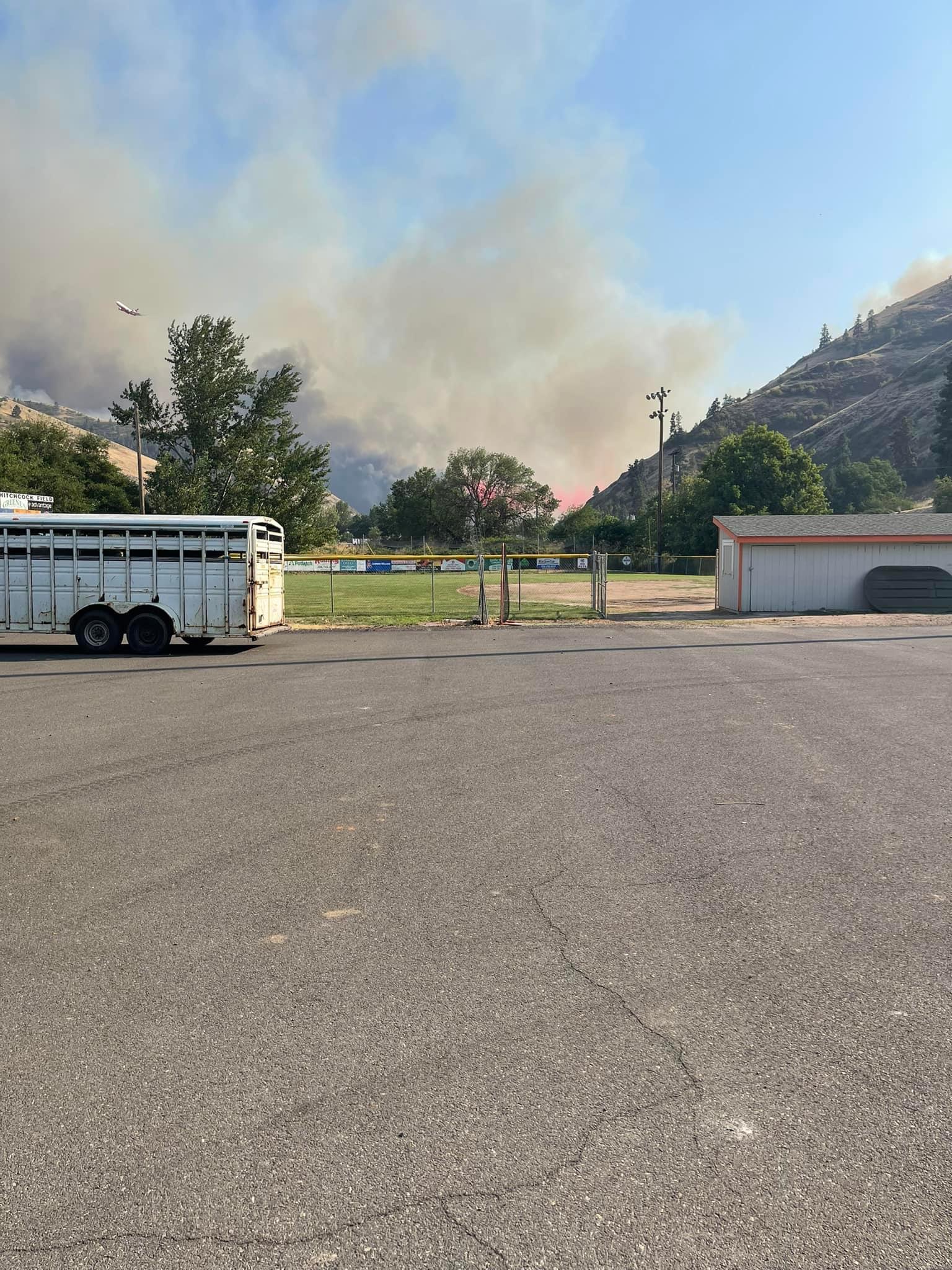 Parking lot and ball field with smoke in distance