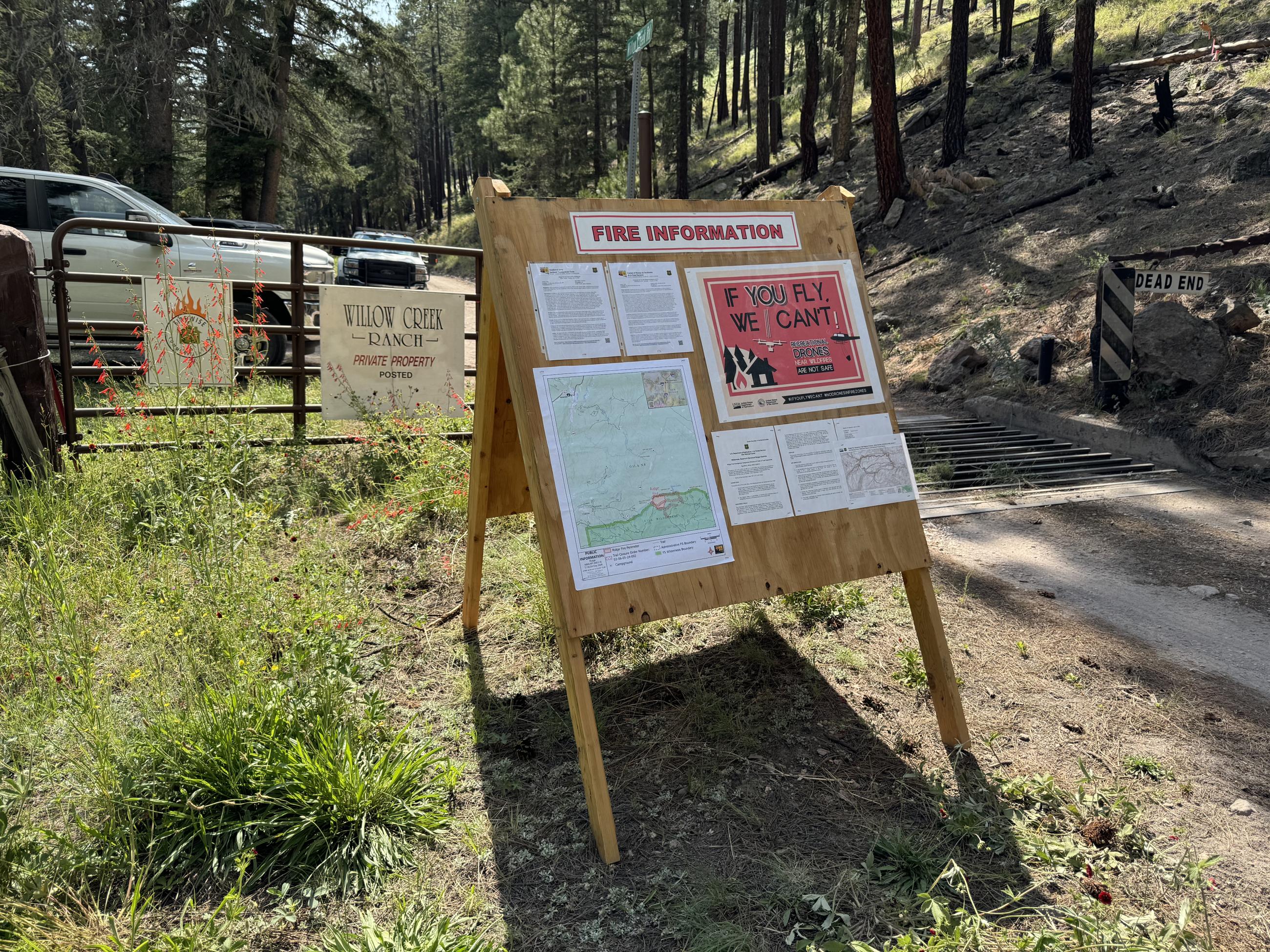 Sandwich board with fire updates and maps at willow creek community gate.