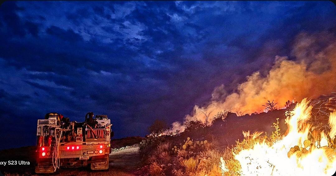 Fire drives on dirt road and light next to active flame