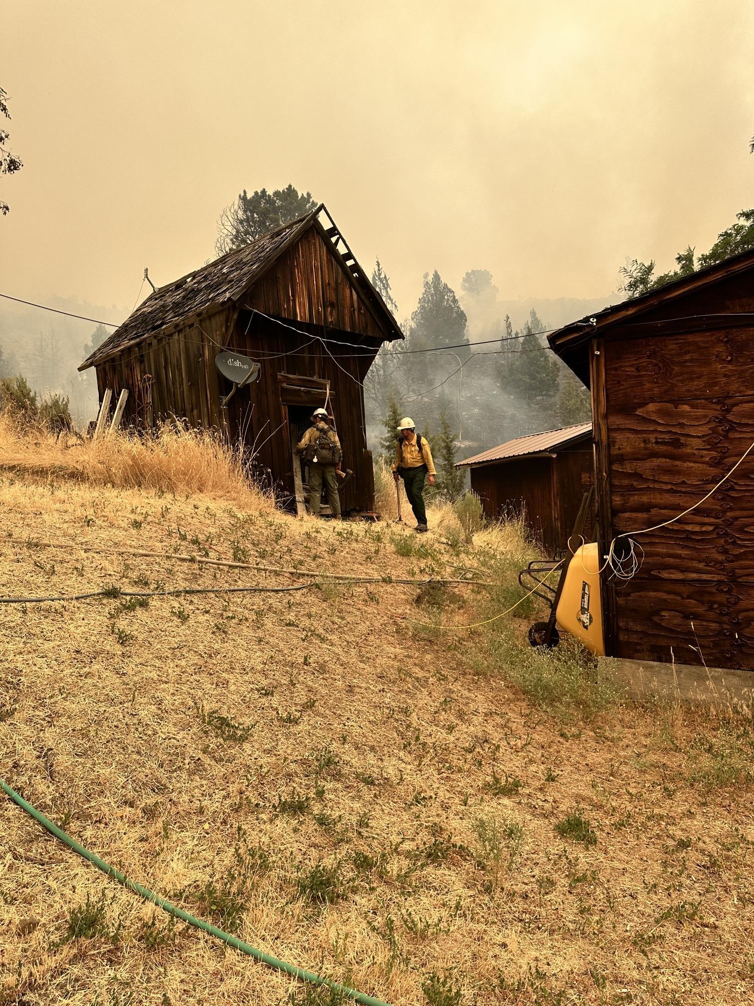 A group of firefighters protects structures on the Lone Rock Fire