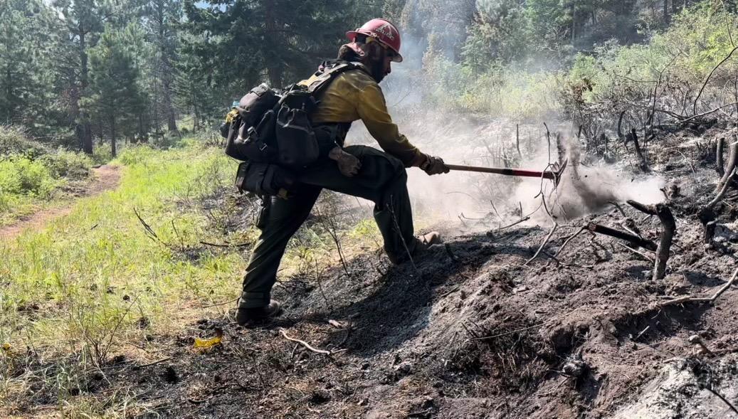 A member of a PatRick crew mopping up and cold trailing on the fire.