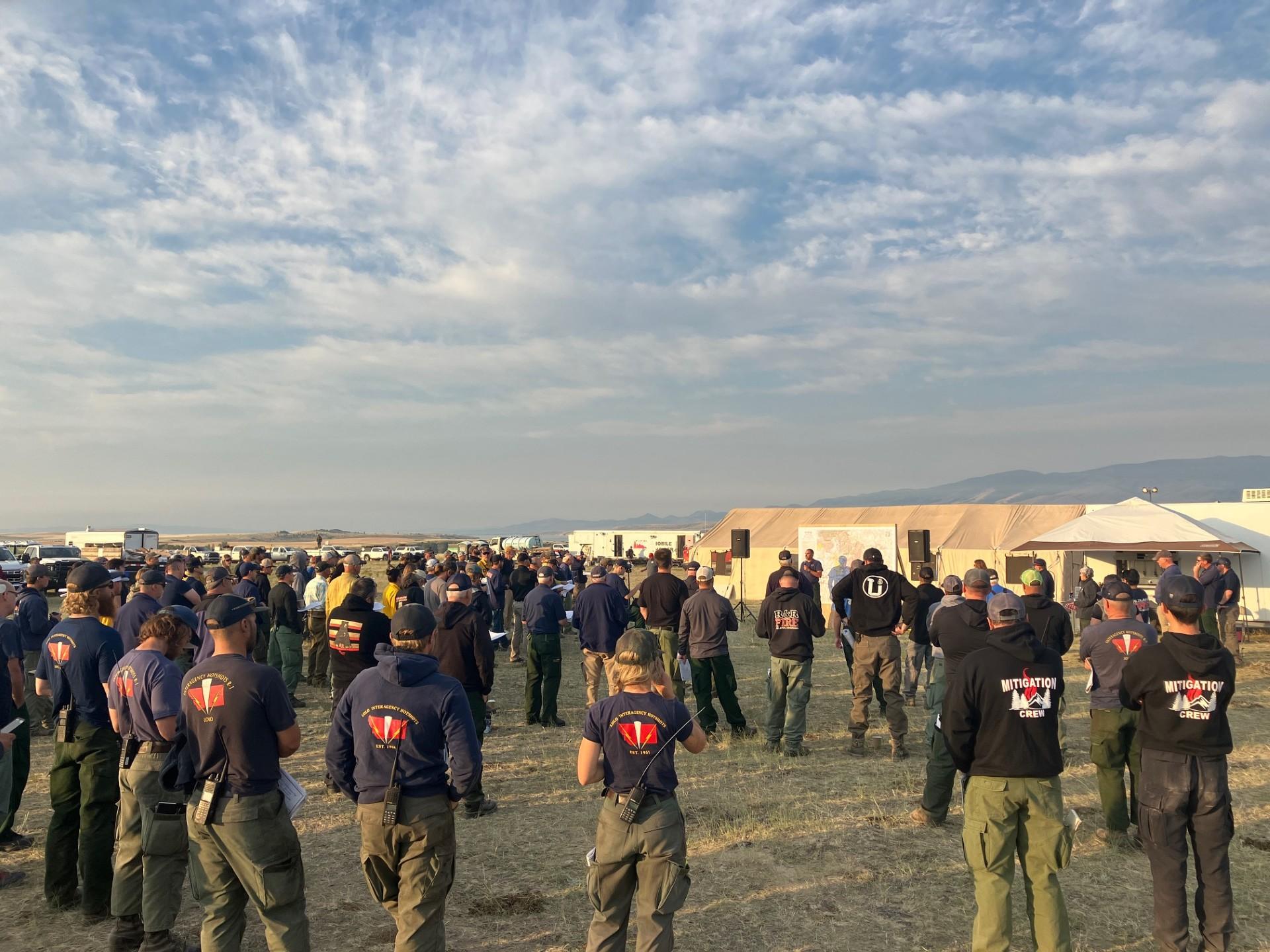 Firefighters standing in front of a map getting briefed for the Horse Gulch Fire