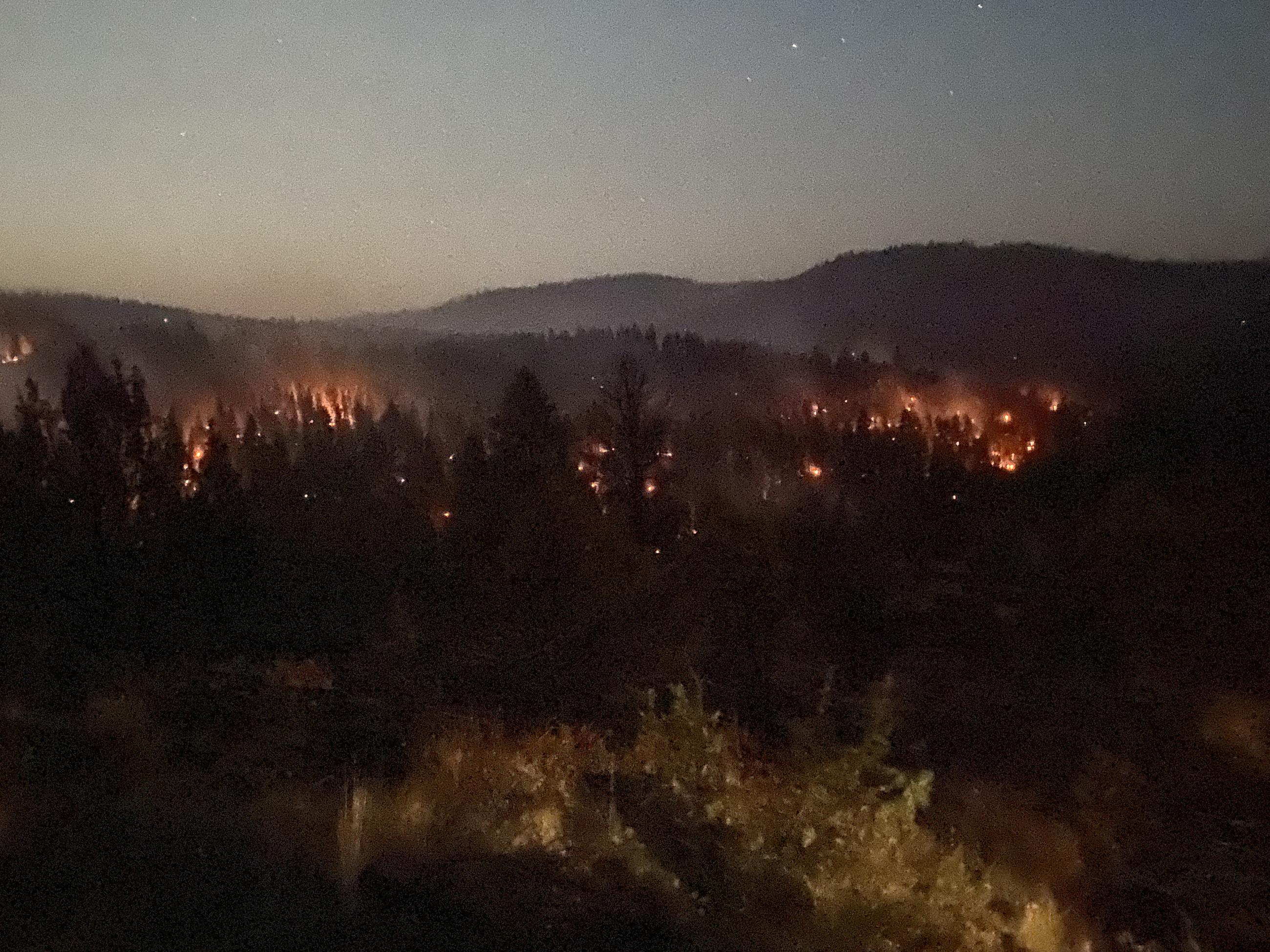 Hills with smoke and fire at dusk