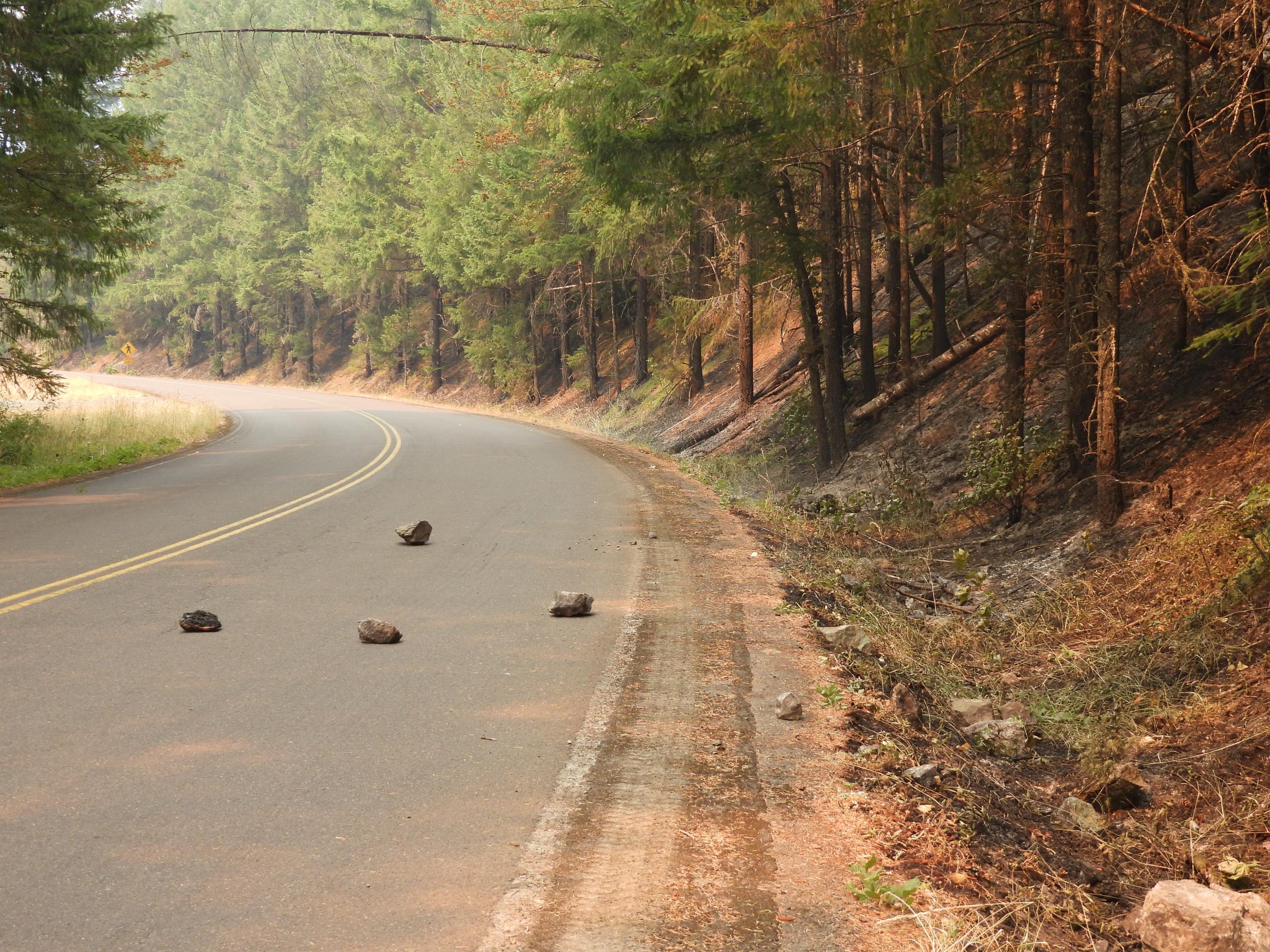 Rocks are seen on the road. Rolling rocks and logs (rollout) are a constant hazard to firefighters.