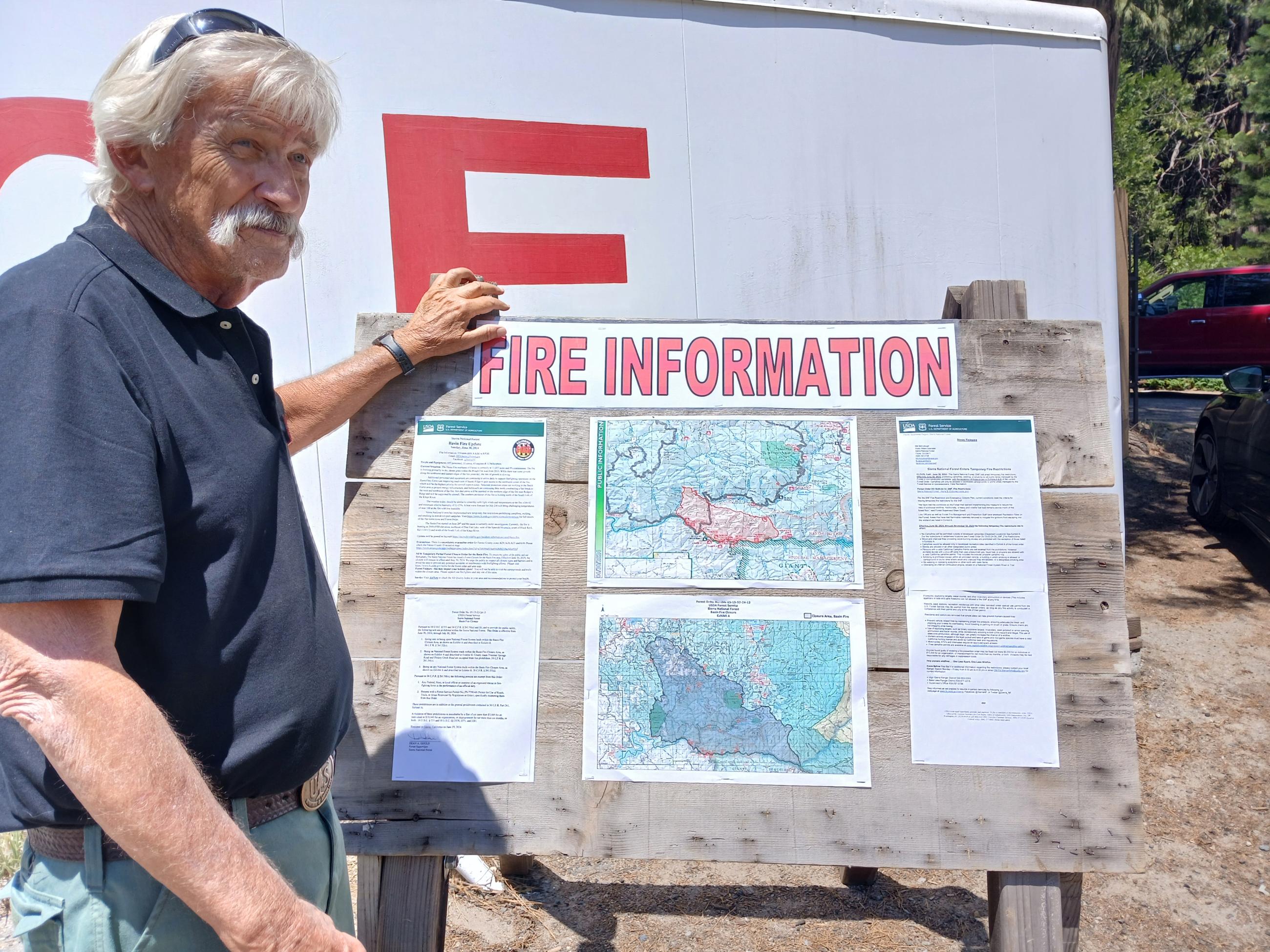 A Fire Public Information Officer updates an Information Board on the Basin Fire.