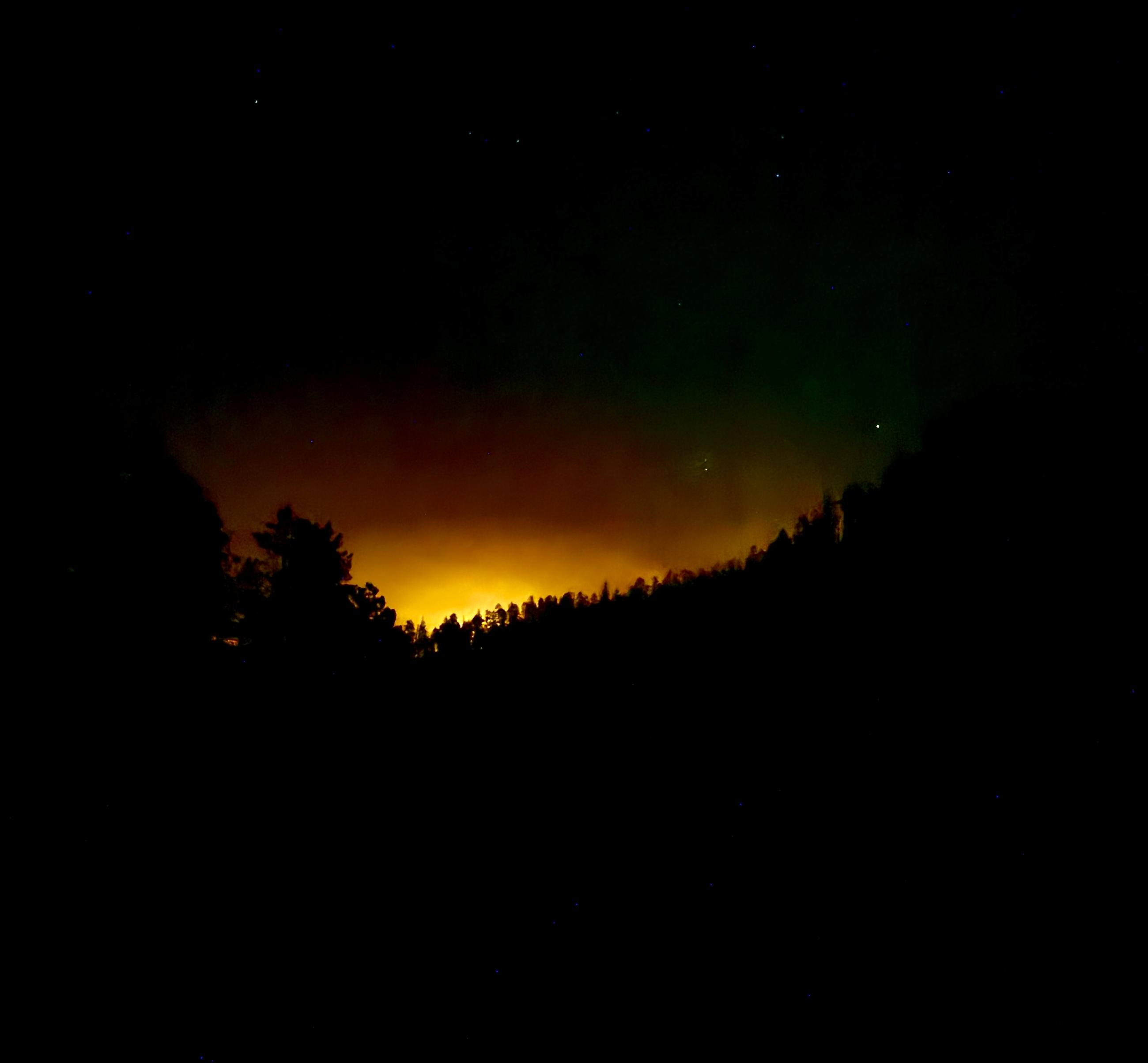 Nighttime with fire over a ridge.