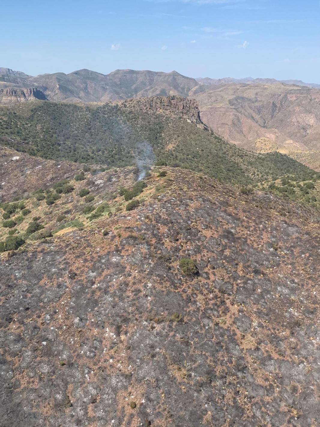 A burned area of mountainous desert is shown in start relief an an unburned backgound. 