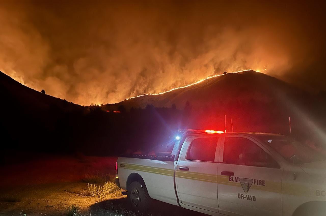 BLM truck watching over ignitions from a firing operations, mountains in the background