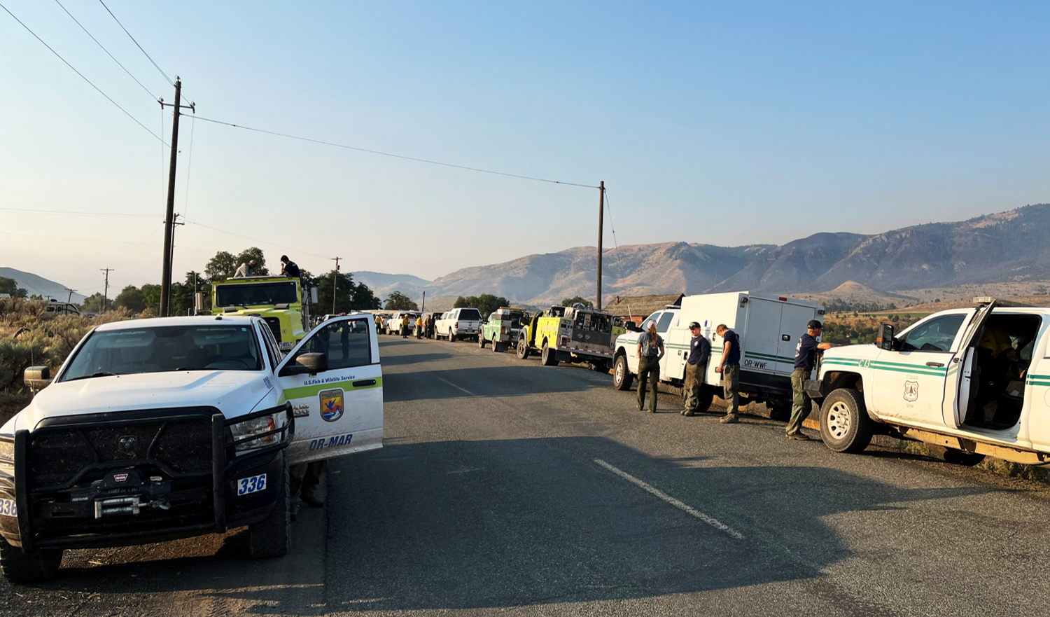 Fire engines parked along roadside, firefighters unloading