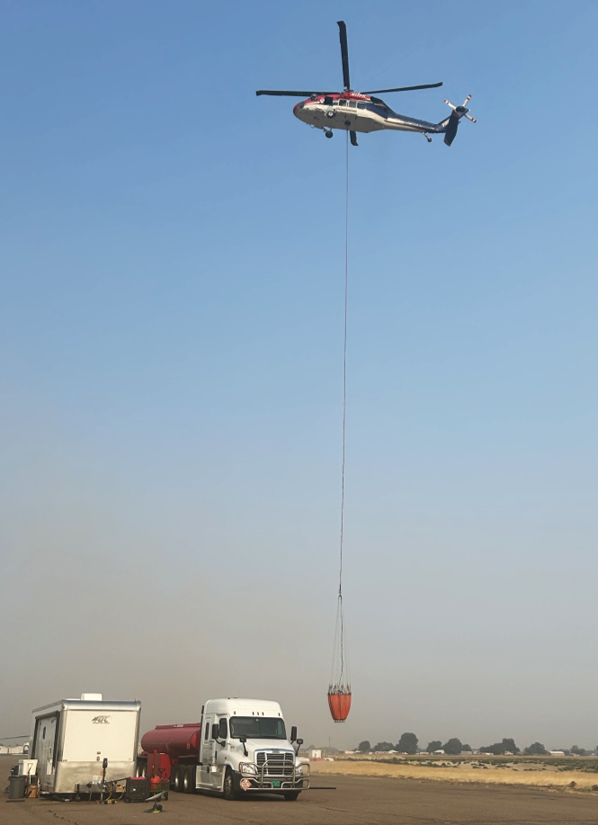 Helicopter with bucket over helibase