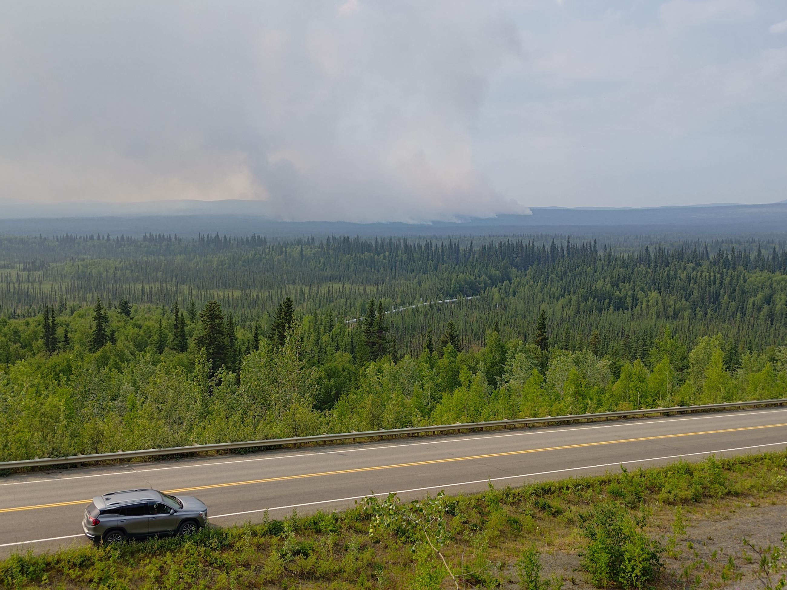 Large smoke column with highway in foreground