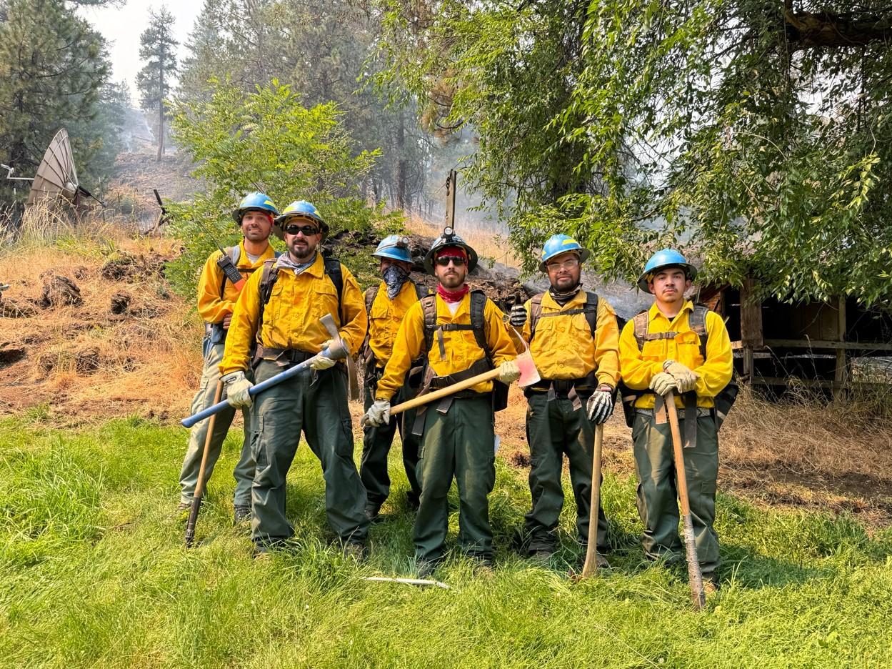 Image of wildland firefighters in firefighting gear posing for a photo. 