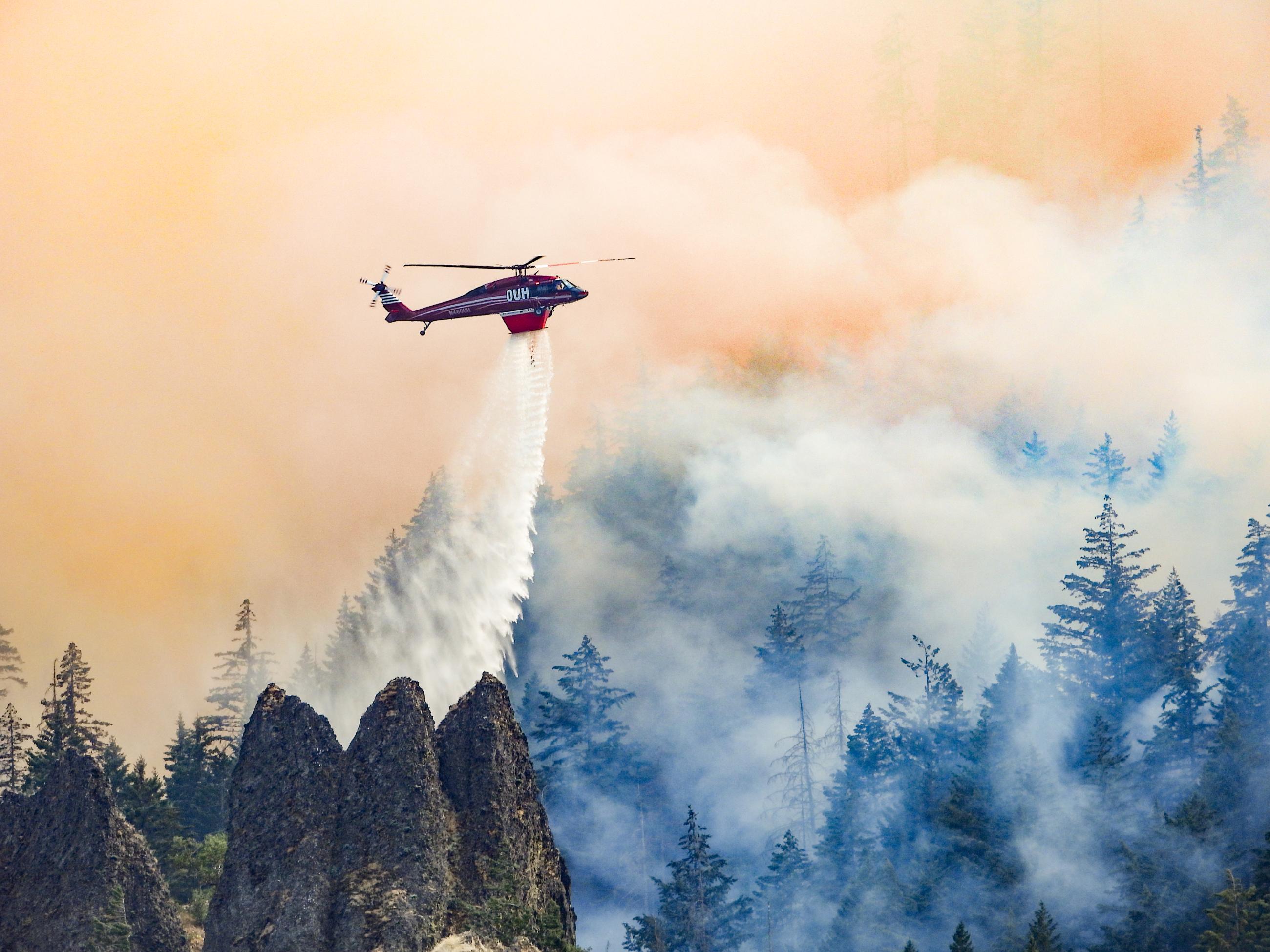 Helicopter Dropping Water to Cool Hotspots on Microwave Tower Fire