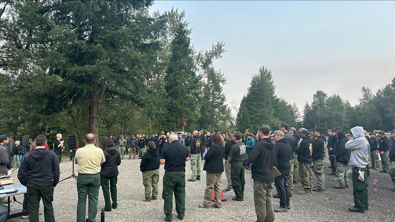 firefighters assemble to receive information at morning briefing, July 26