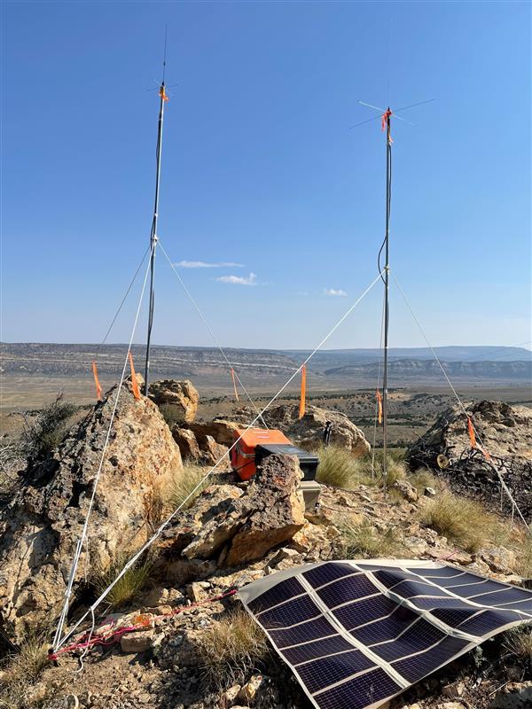 two temporary radio antennae are installed on top of a mountain to improve communications