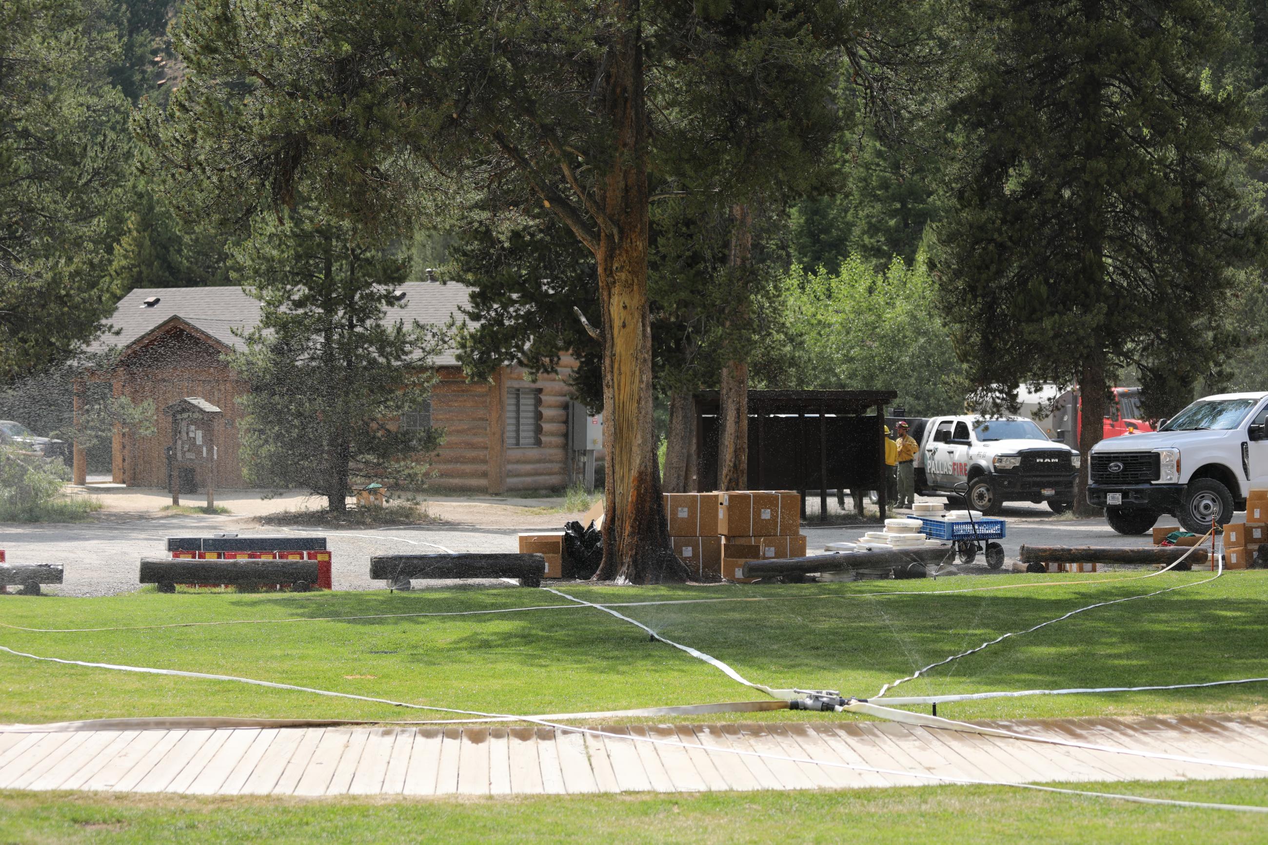 Hoses, sprinklers, and water pumps for structure protection are being placed throughout the Redfish Lodge area.