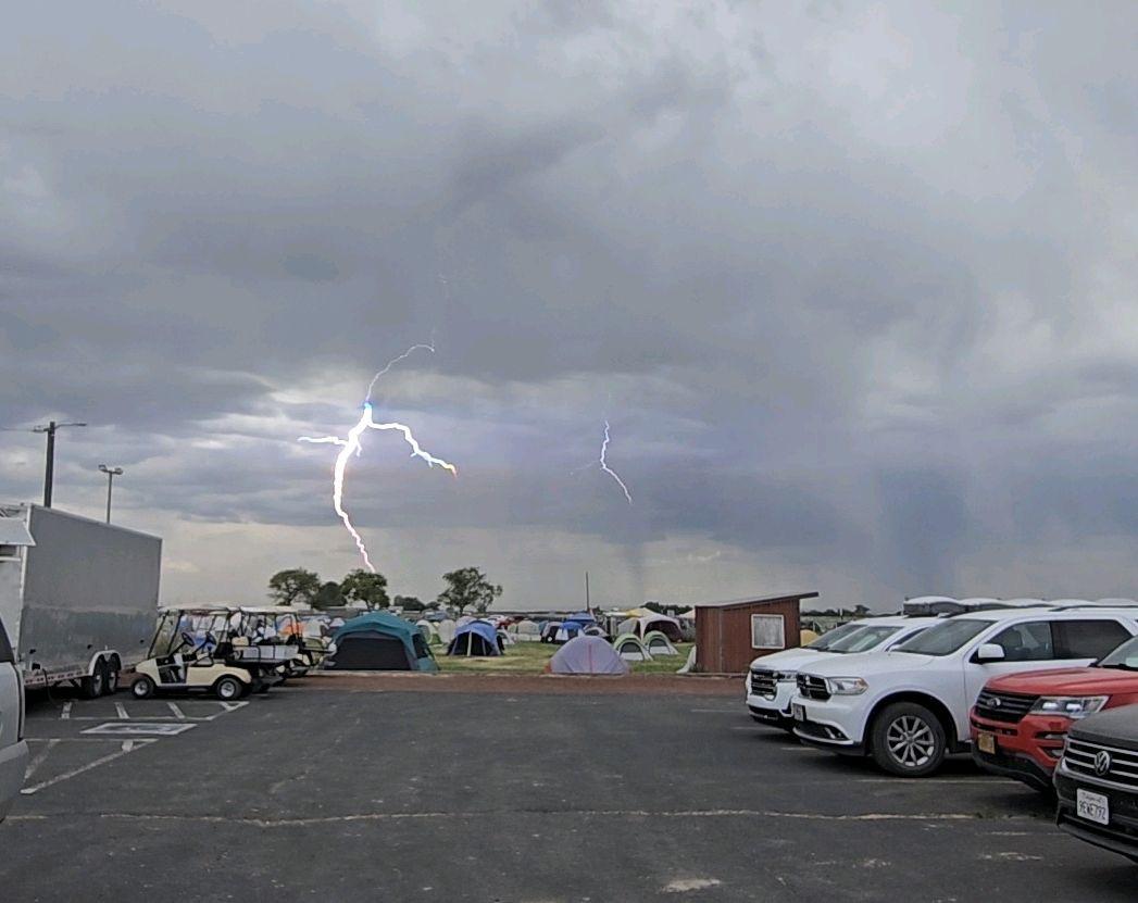 Lightning and cloudy sky over parking lot with cars