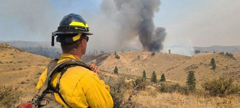 A Wildland Firefighter on the Black Canyon Fire observes a smoke column from the adjacent ridge