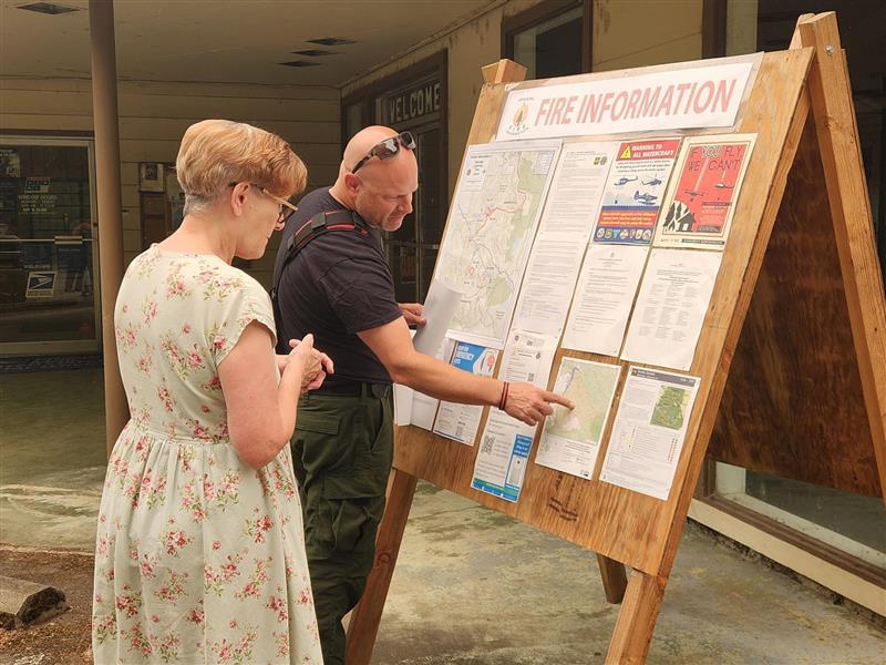 a public information speaks to a woman at an information board