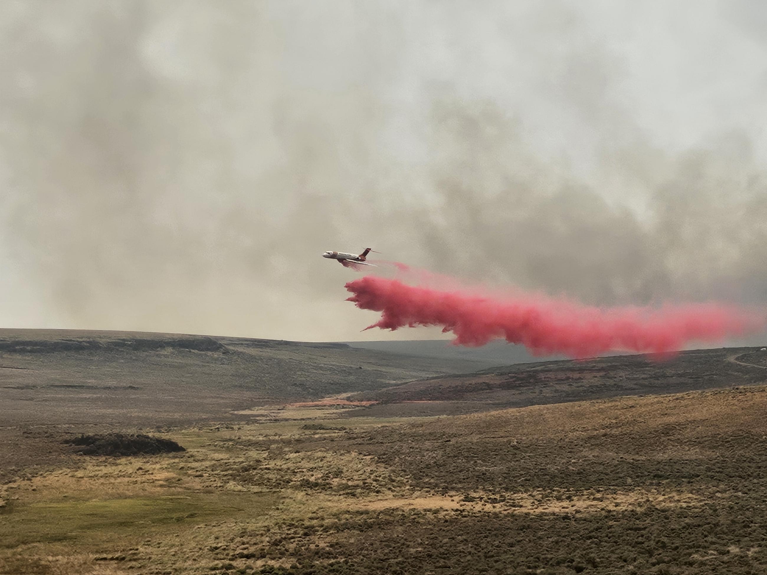 this is a photo of a large plane dropping retardant on the Warner Peak Fire