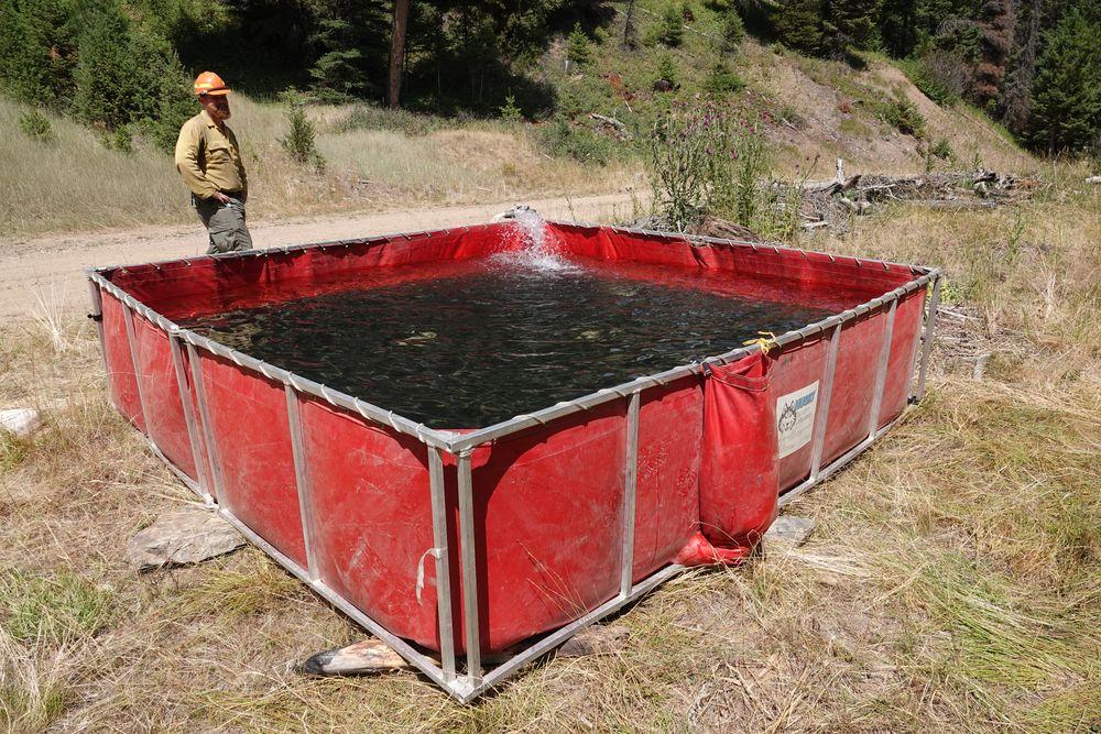 Large red folding tank in a frame filling with water