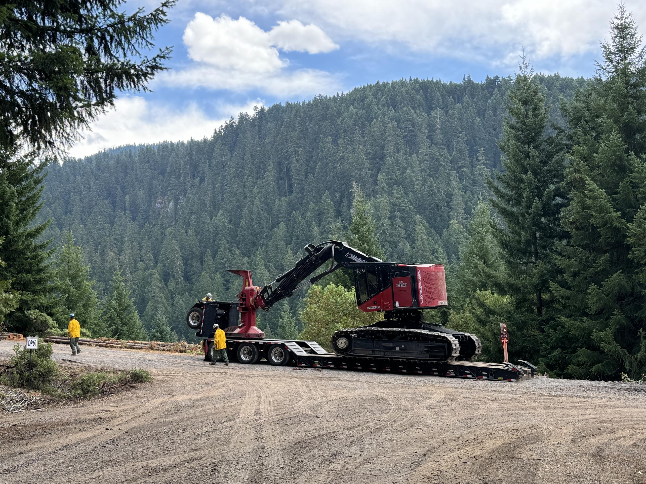 large red machine on semi truck and trailer