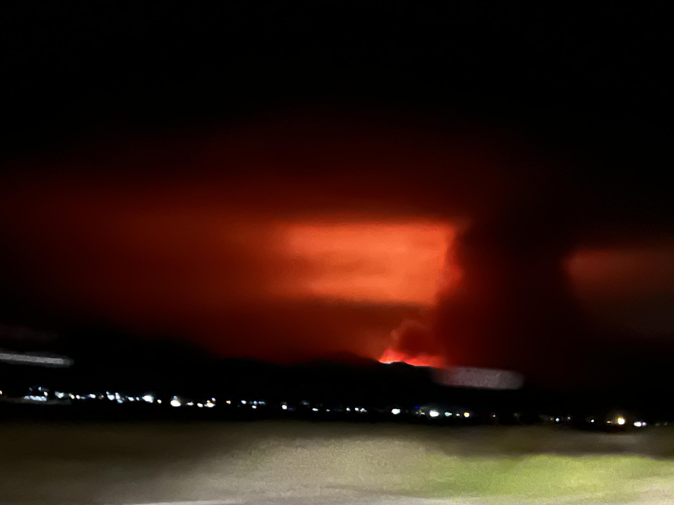 Distant view of Element Fire against nighttime skyline.