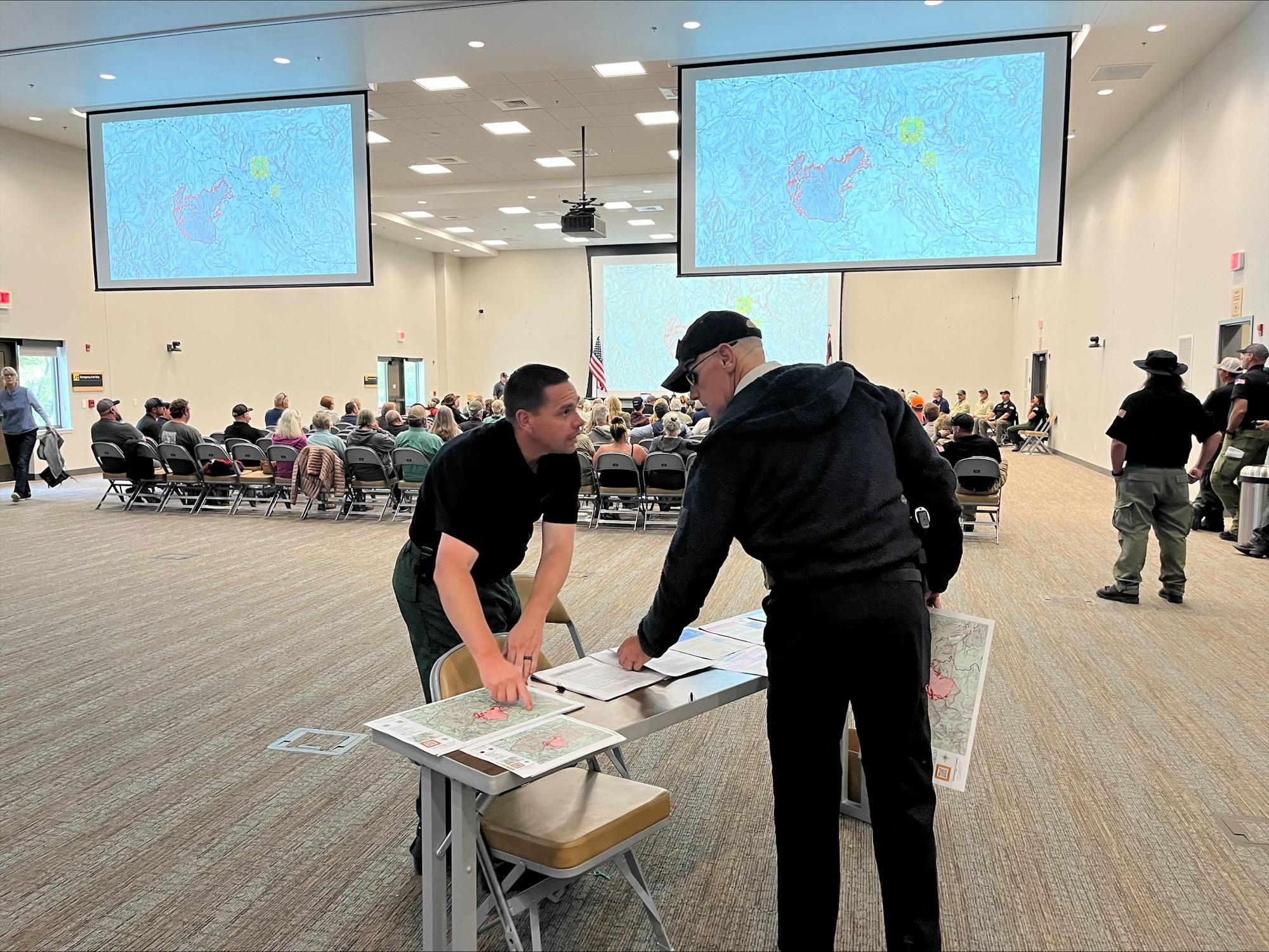 Public information officer speaking with public at the public meeting