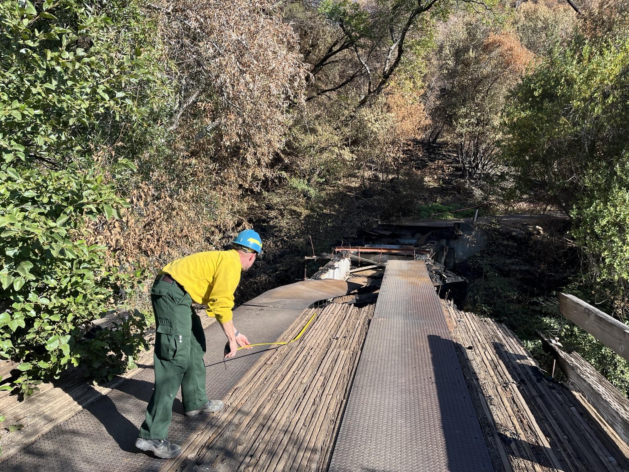 Image showing BAER Engineer Todd Orange Assessing Black Rock Bridge Damaged in Park Fire