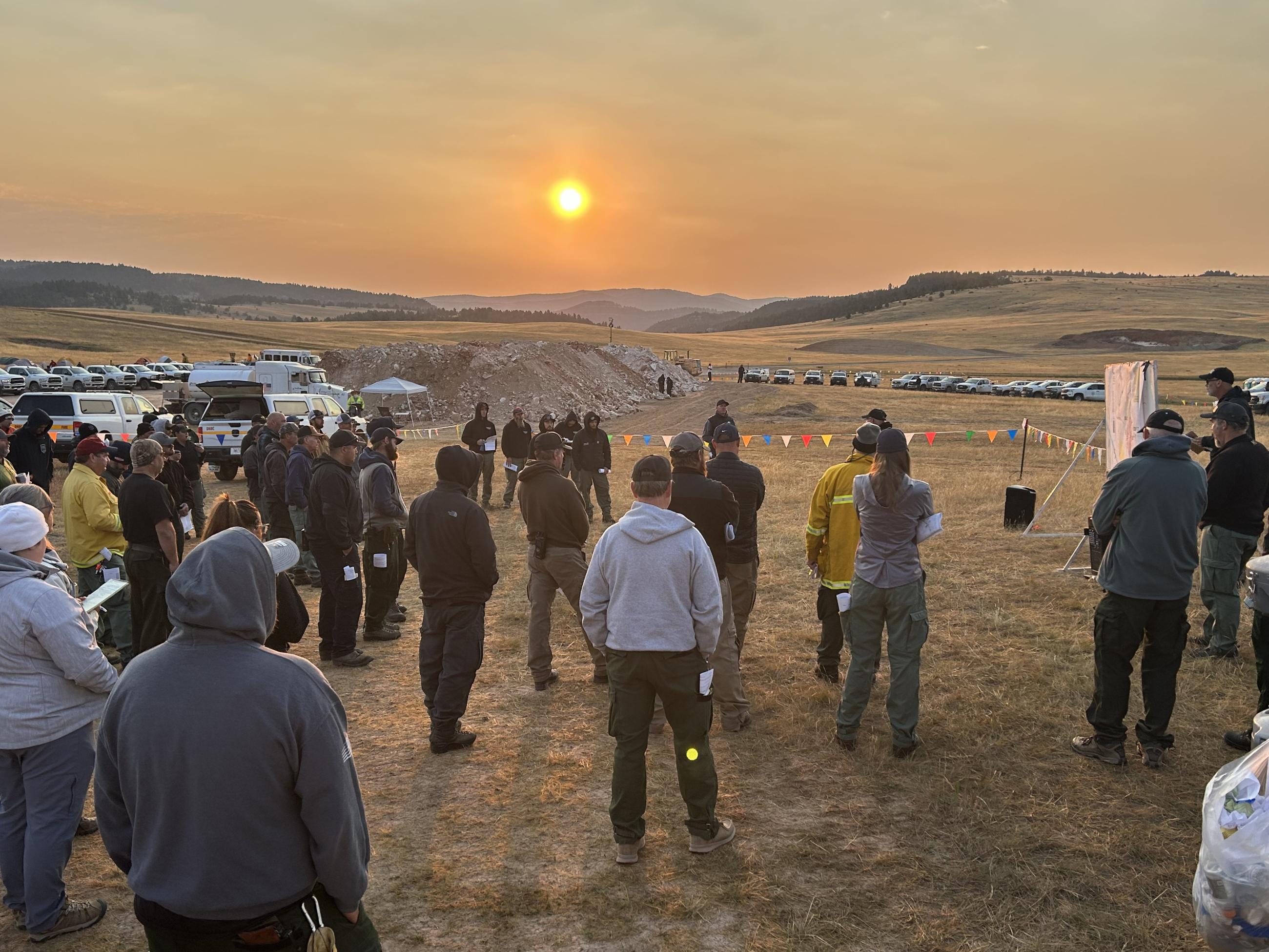 Firefighters and County Assist Team members gather in the morning for an operations briefing