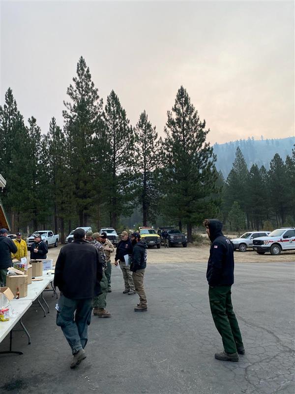 firefighters gather around tables outside for breakfast at lowman fire station on Aug 25