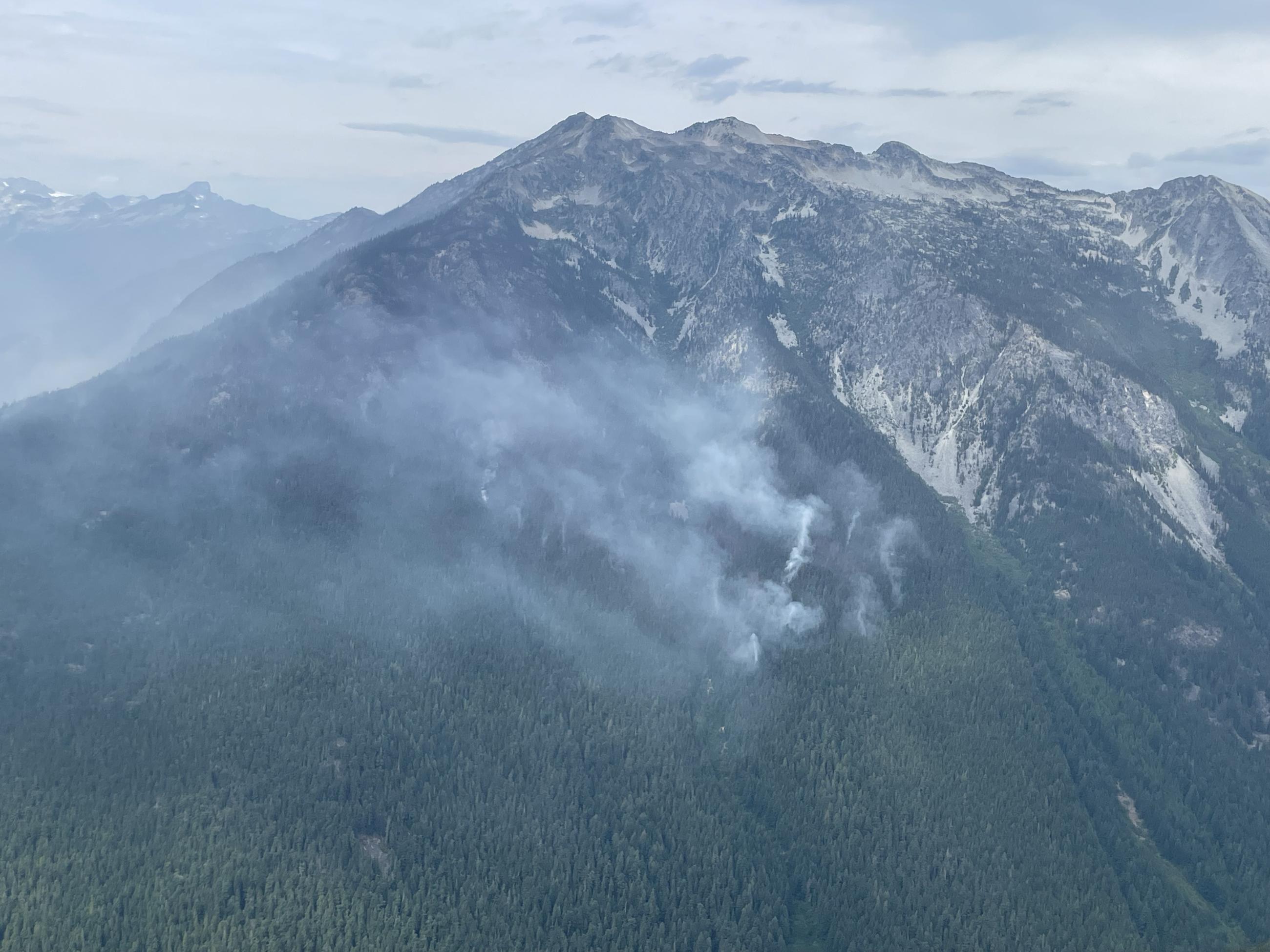 Aerial image of Ruby Mountain and smoke wafting up from the forest in the distance