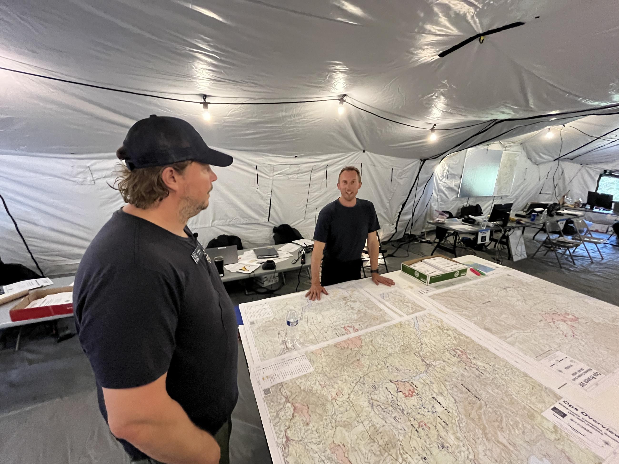 guy in tent by big map on table