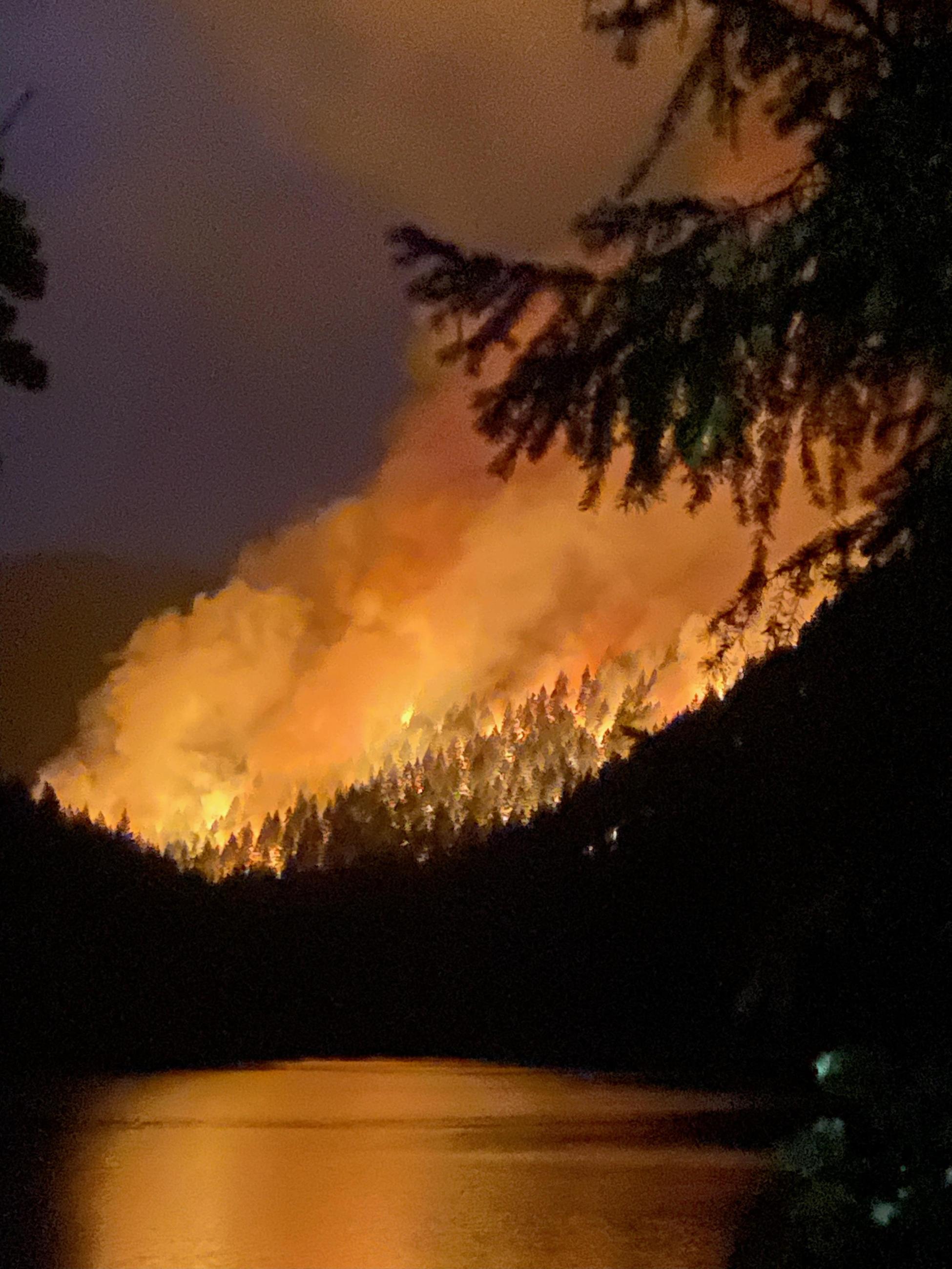 Coffeepot Fire burns actively with lake in forefround, Friday night, August 2