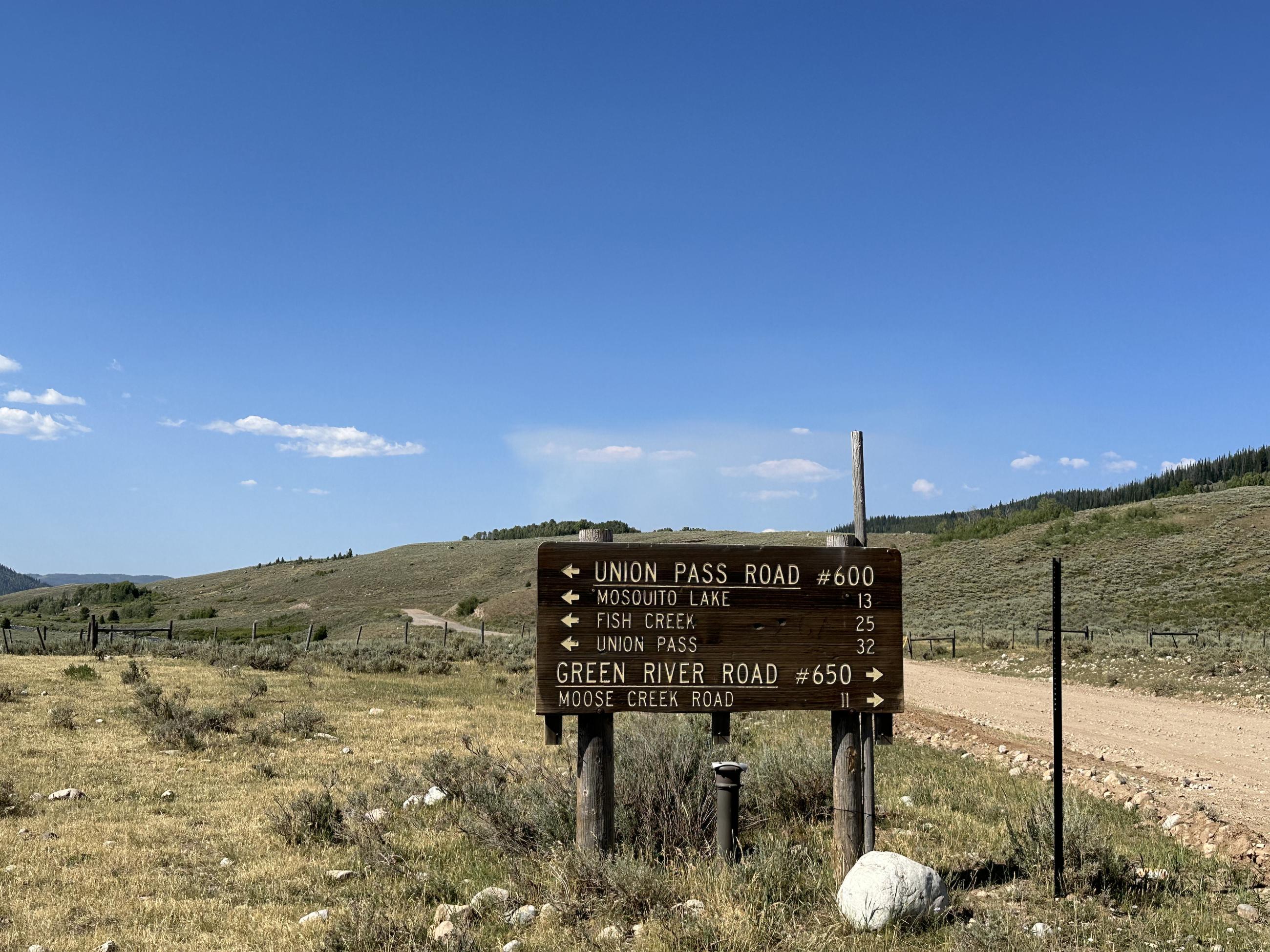 Union Pass Road Sign along road with smoke dispersal behind