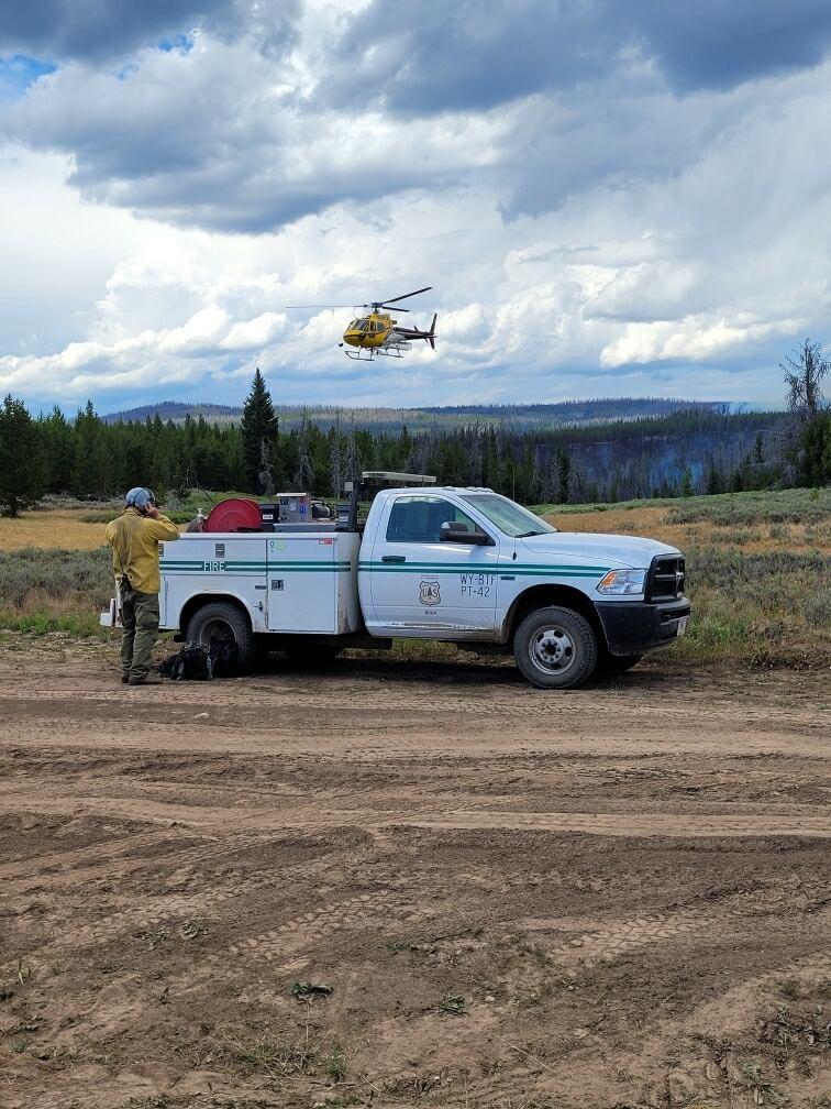 Helicopter landing with fire engine an personnel in front